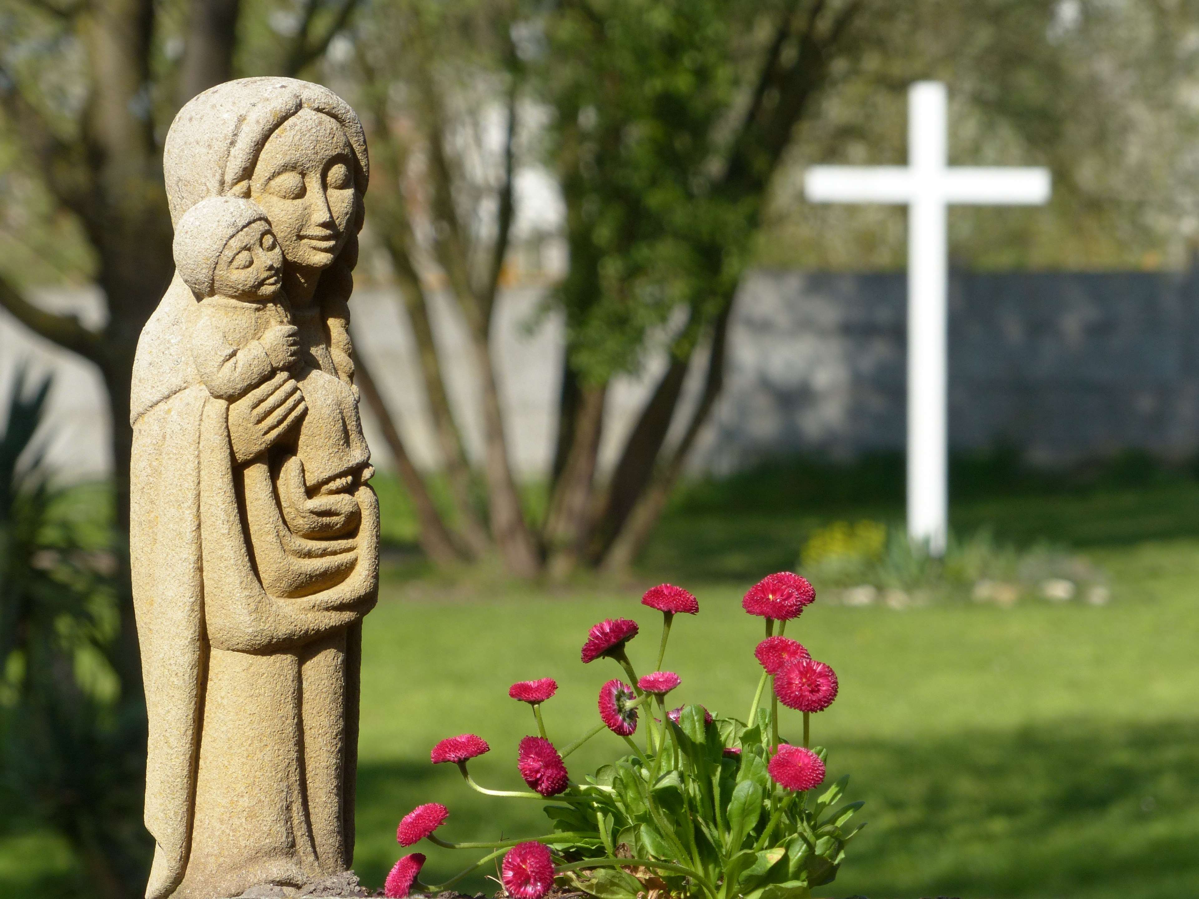 Statue of Virgin Mary holding Child Jesus with cross in background HD Wallpaper