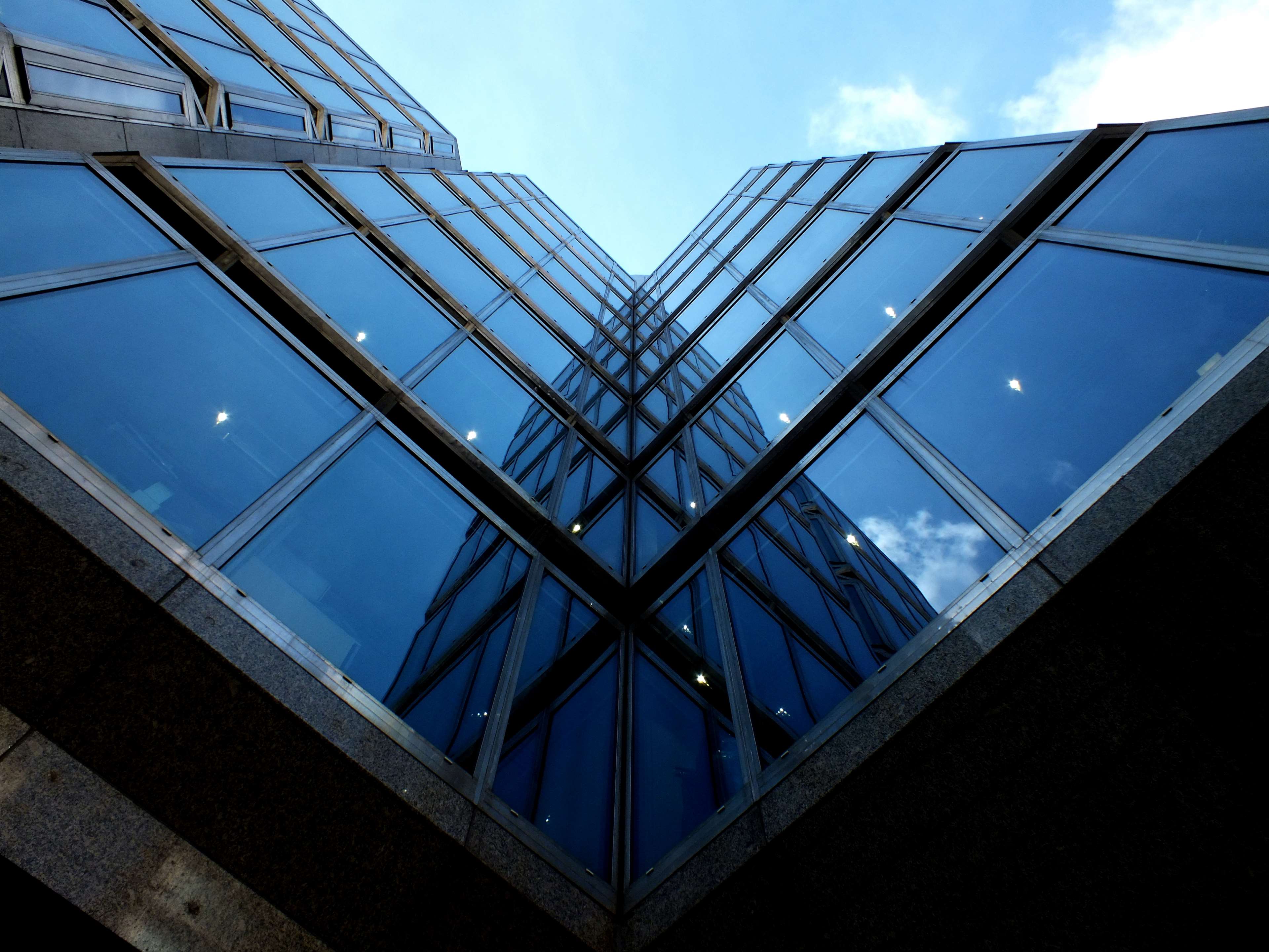 Modern glass building reflecting the sky HD Wallpaper