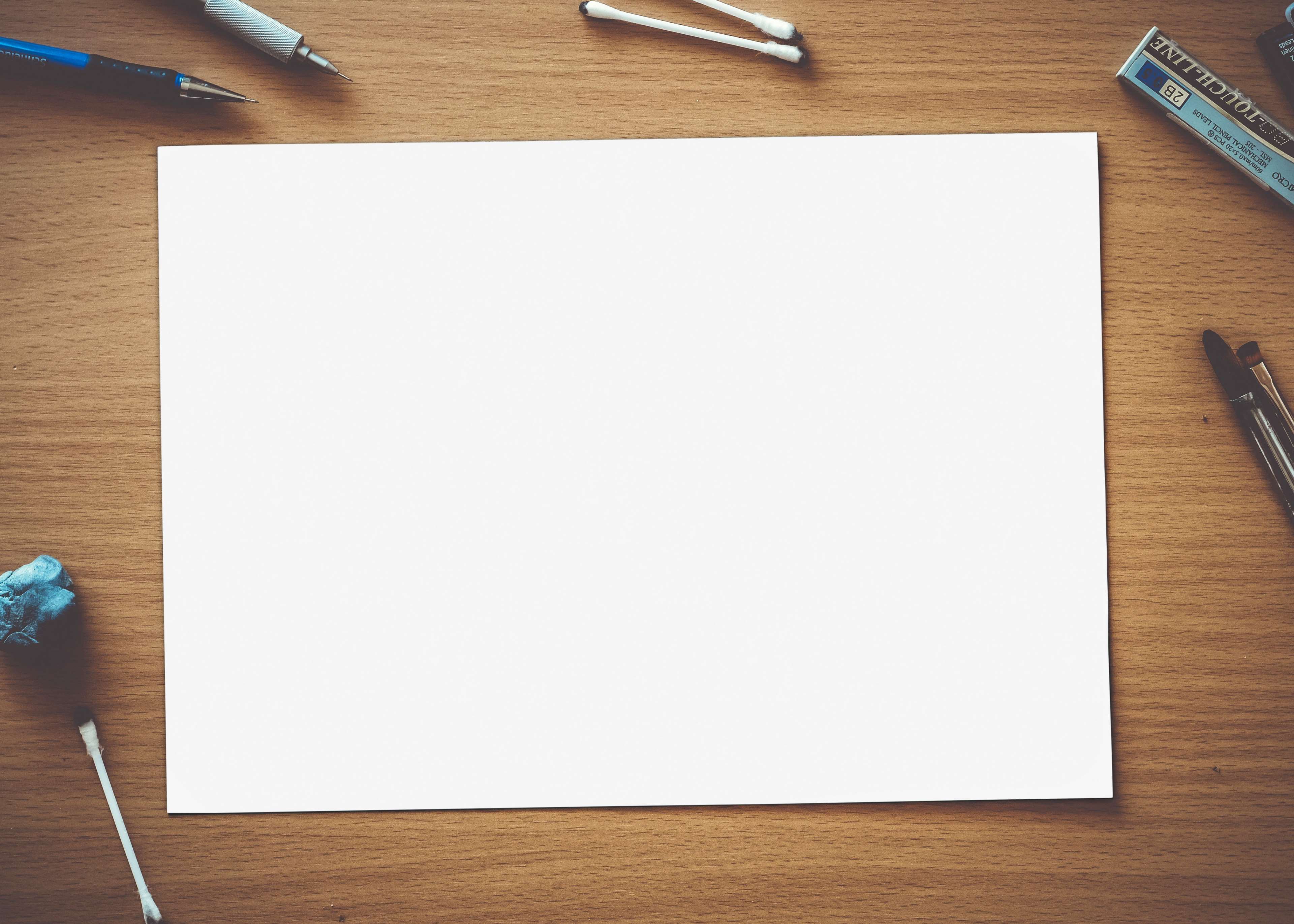 Art materials on a wooden surface with blank paper HD Wallpaper