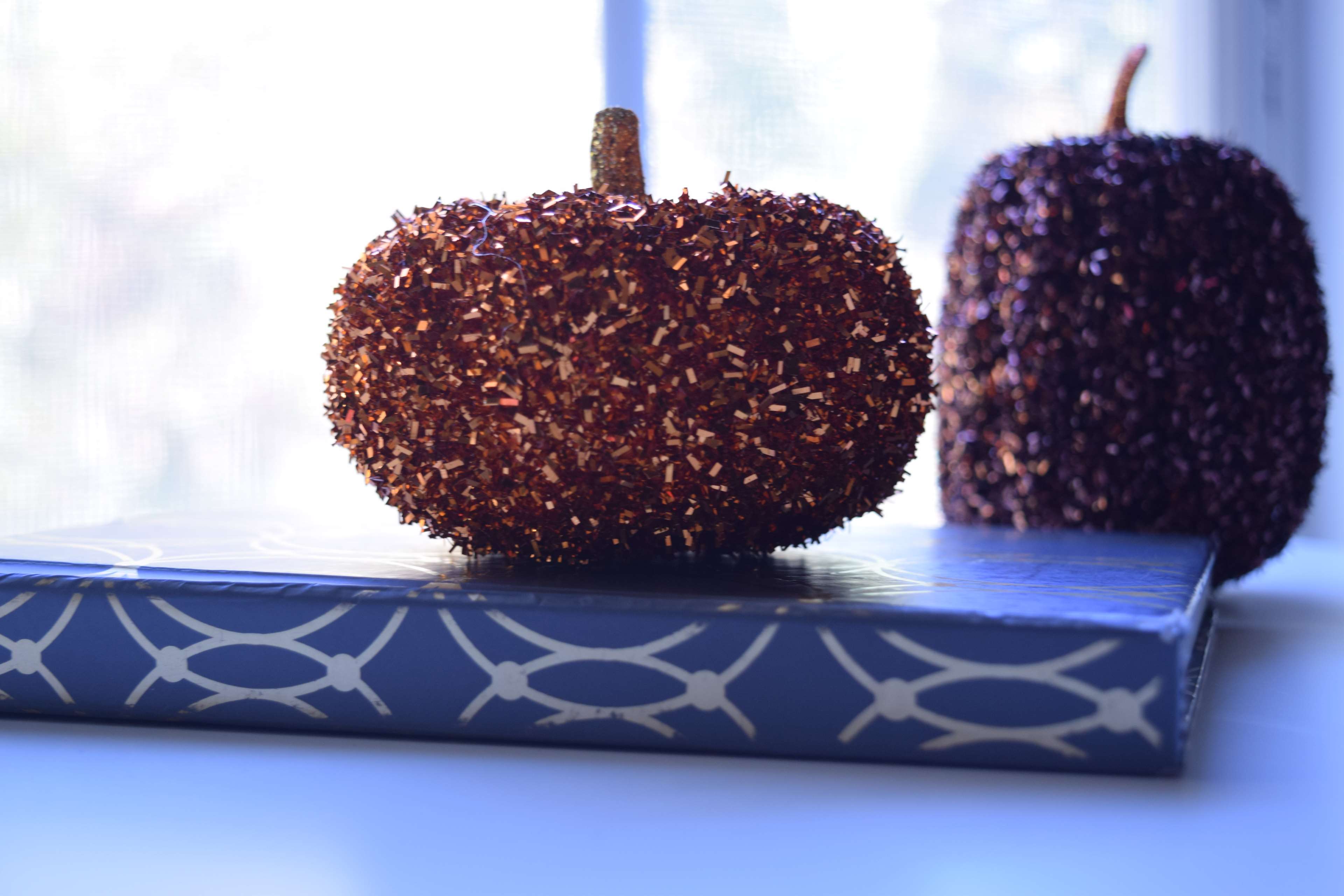 Two glitter pumpkins on a book HD Wallpaper