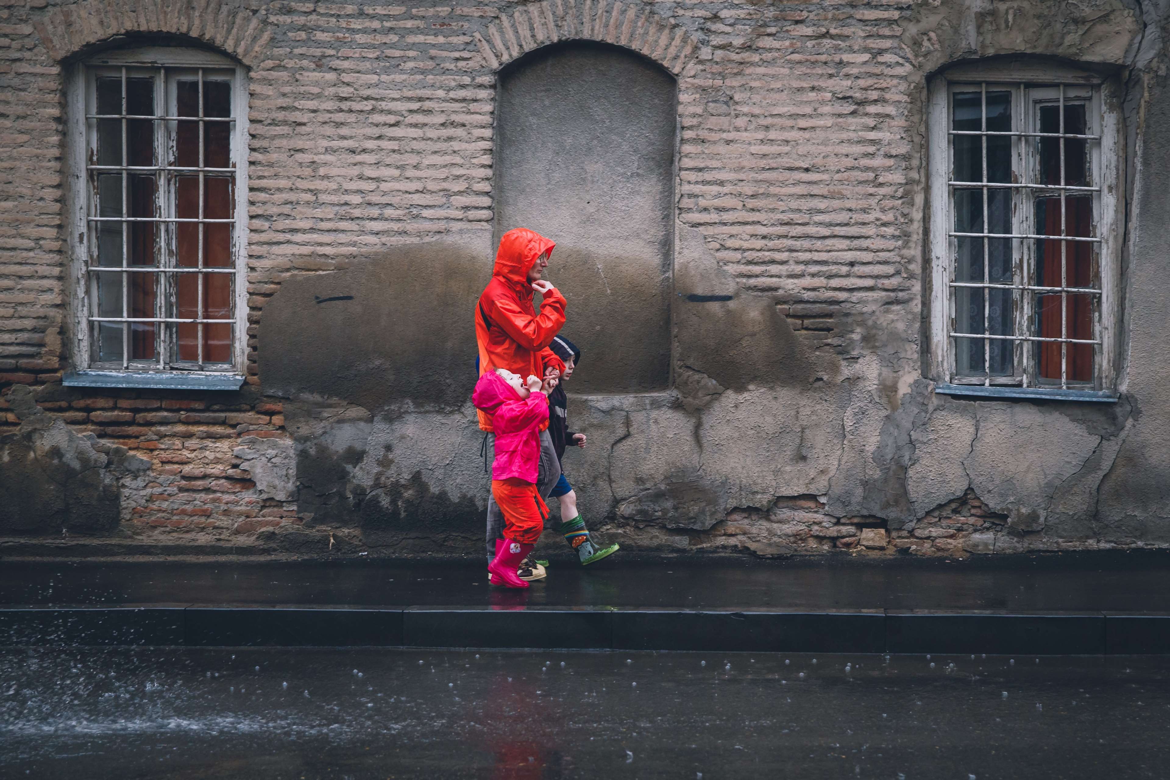 People walking in the rain on a brick street HD Wallpaper