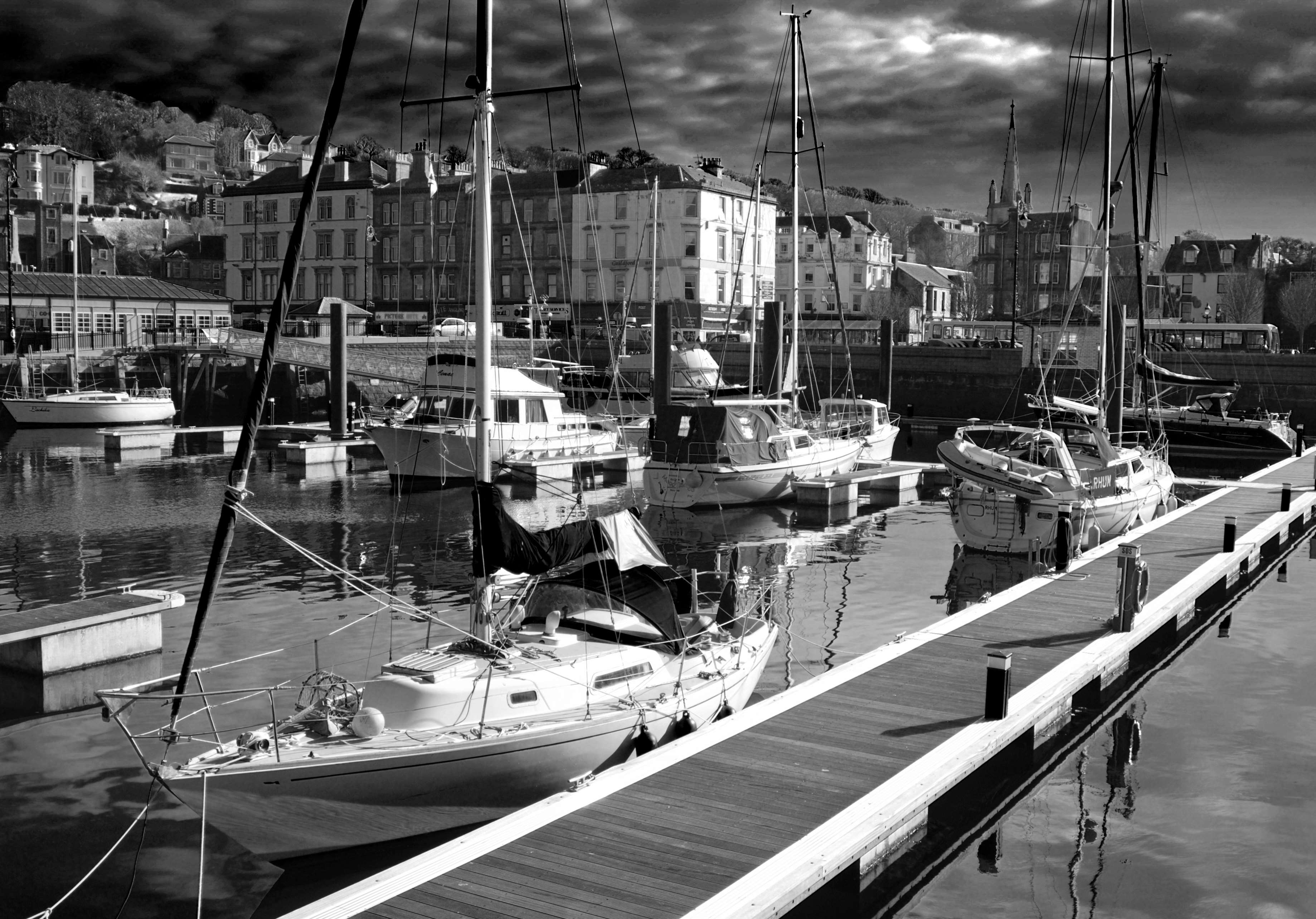 Sailboats docked in a harbor with buildings in the background HD Wallpaper