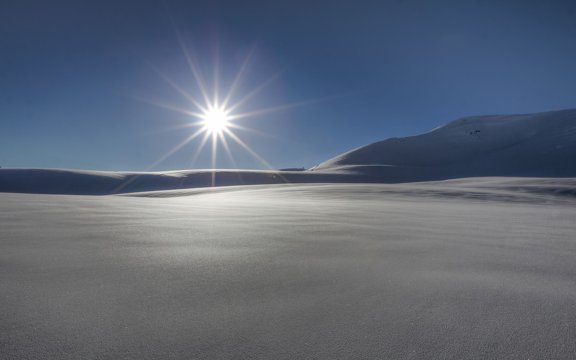 Sun shining over snow-covered hills HD Wallpaper
