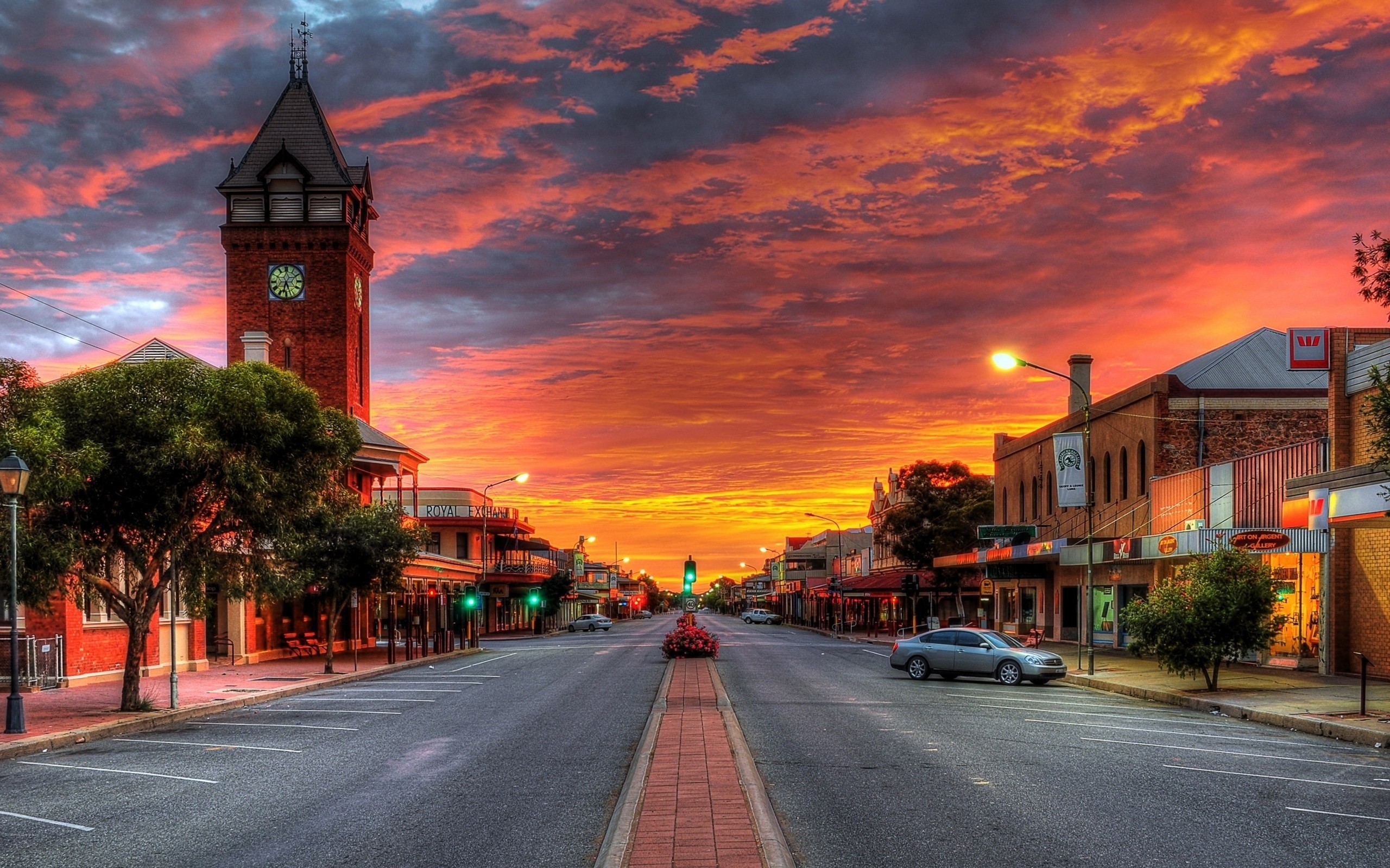 Street scene at sunset with a clock tower HD Wallpaper
