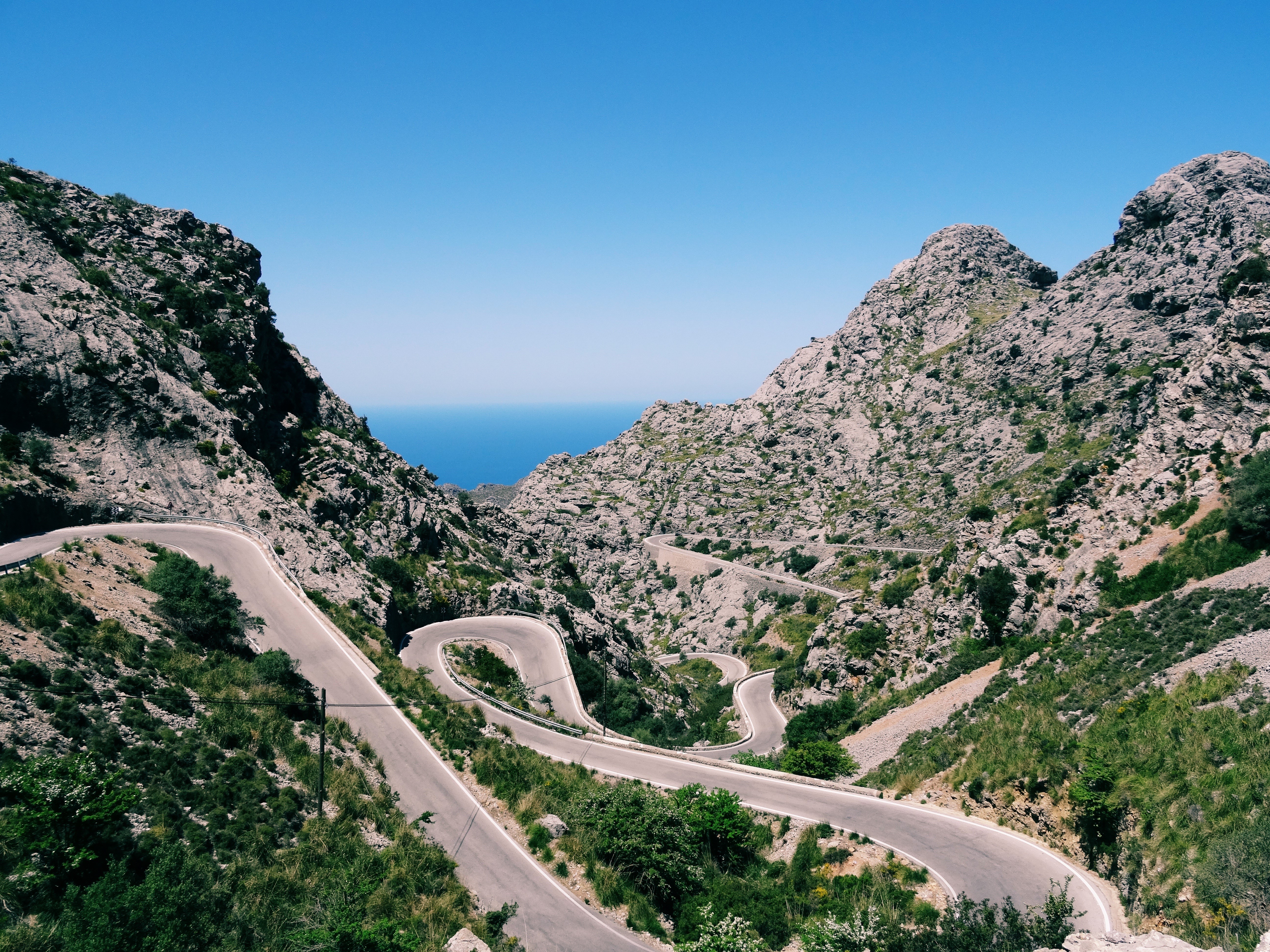 Winding mountain road overlooking the sea HD Wallpaper