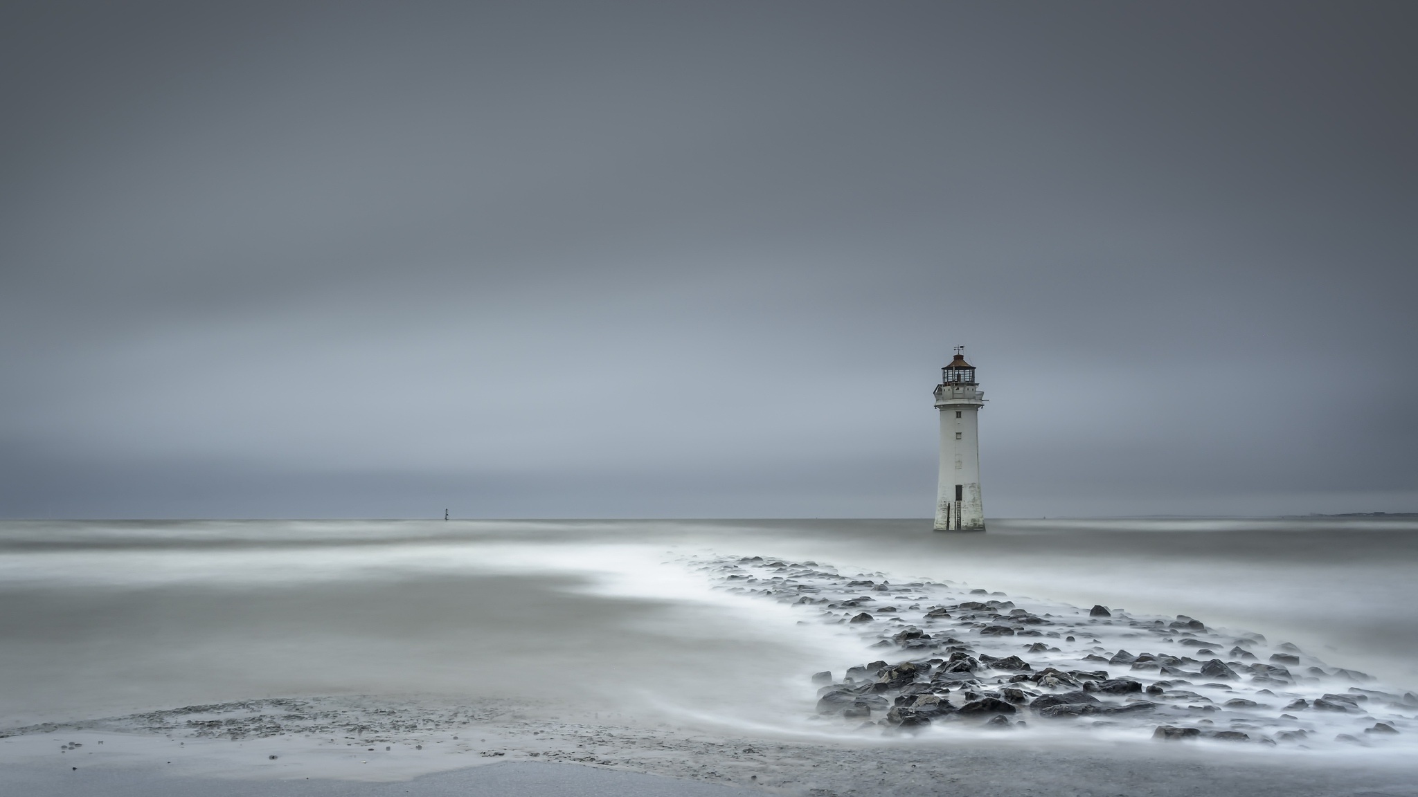Lighthouse on the ocean with a rocky shore HD Wallpaper