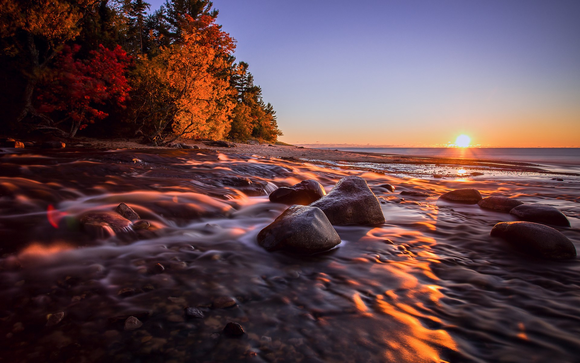 Sunset over a rocky stream and autumn trees HD Wallpaper