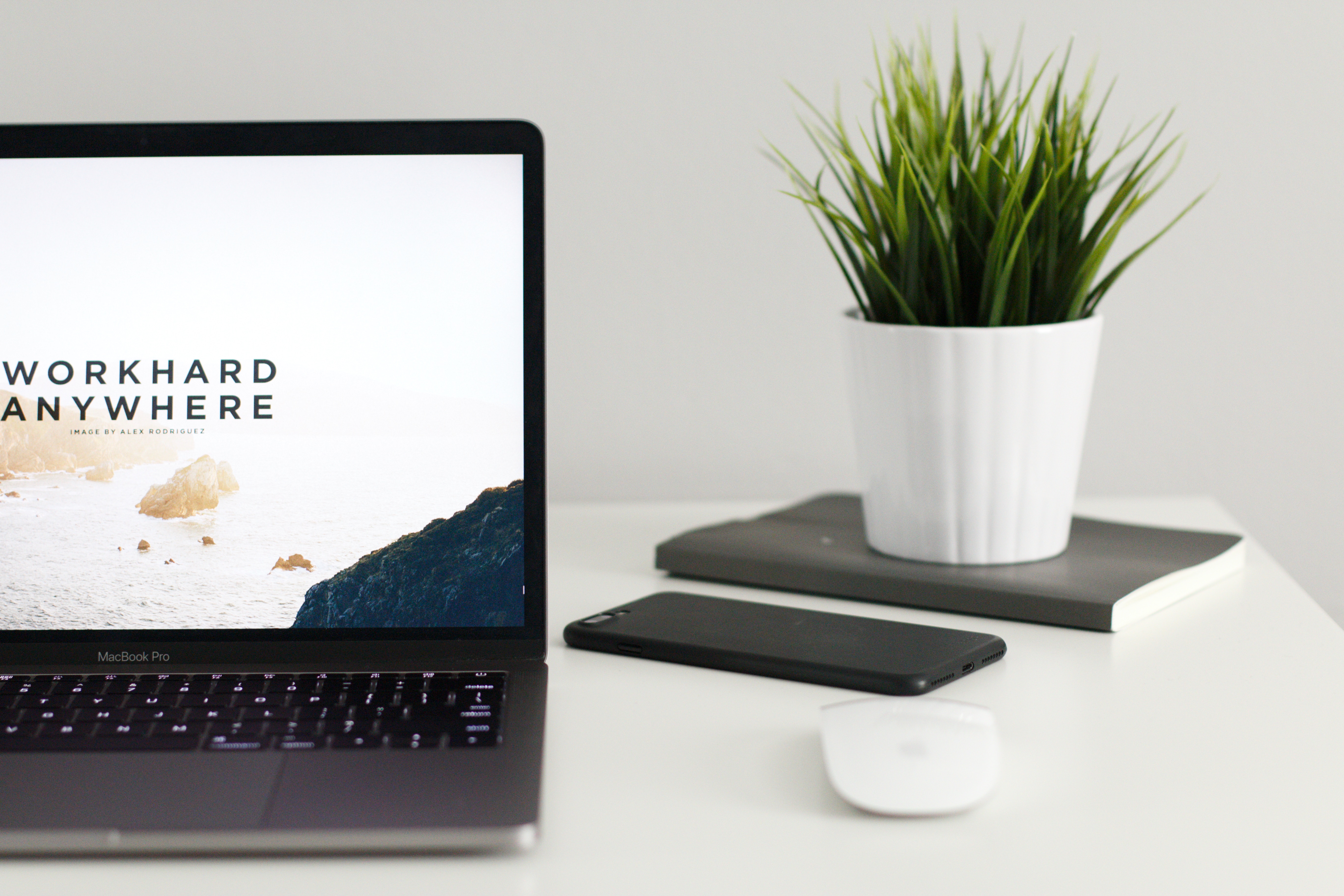 MacBook Pro with potted plant and phone on desk HD Wallpaper