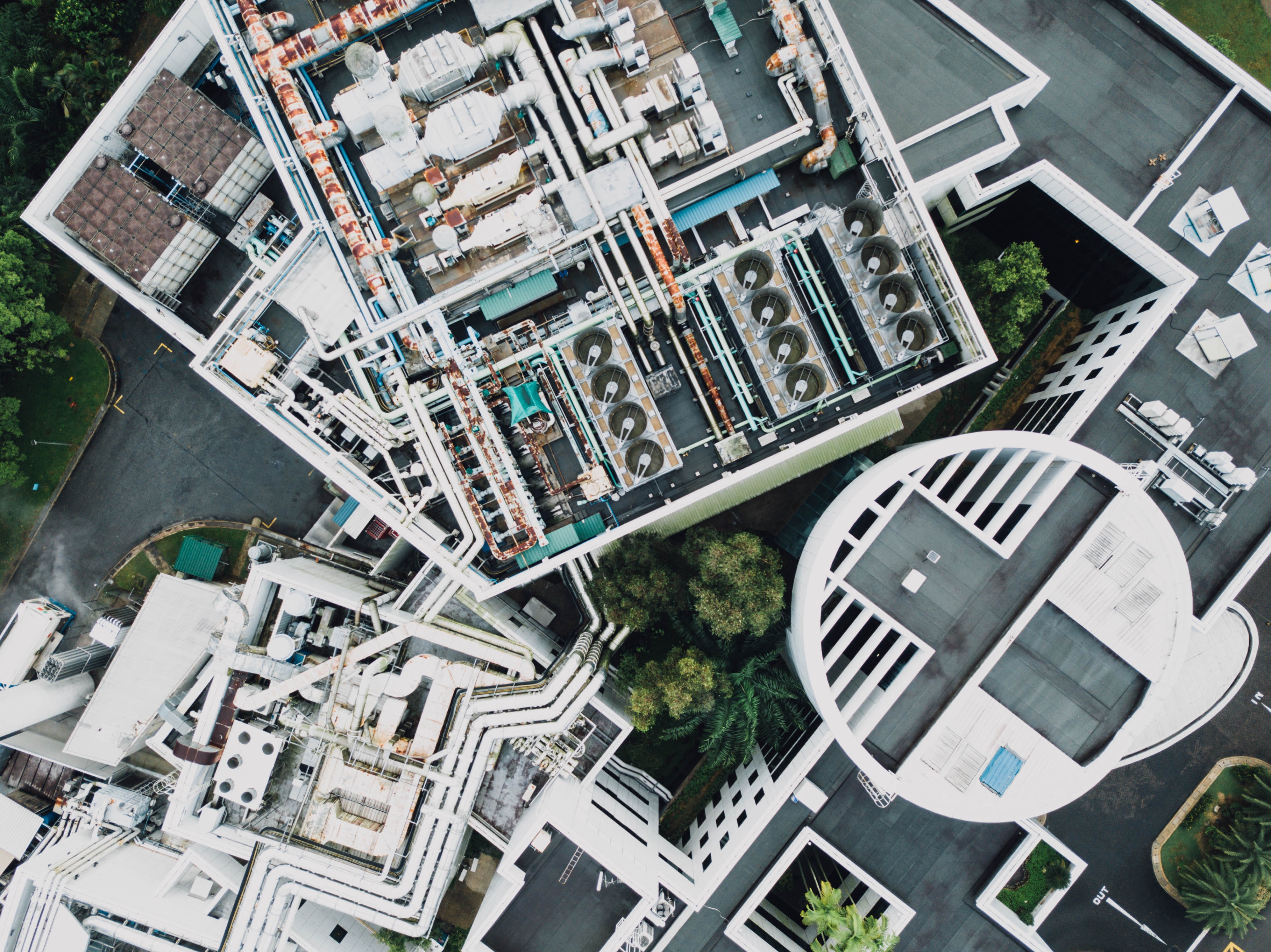 Aerial view of industrial building rooftop with complex piping HD Wallpaper