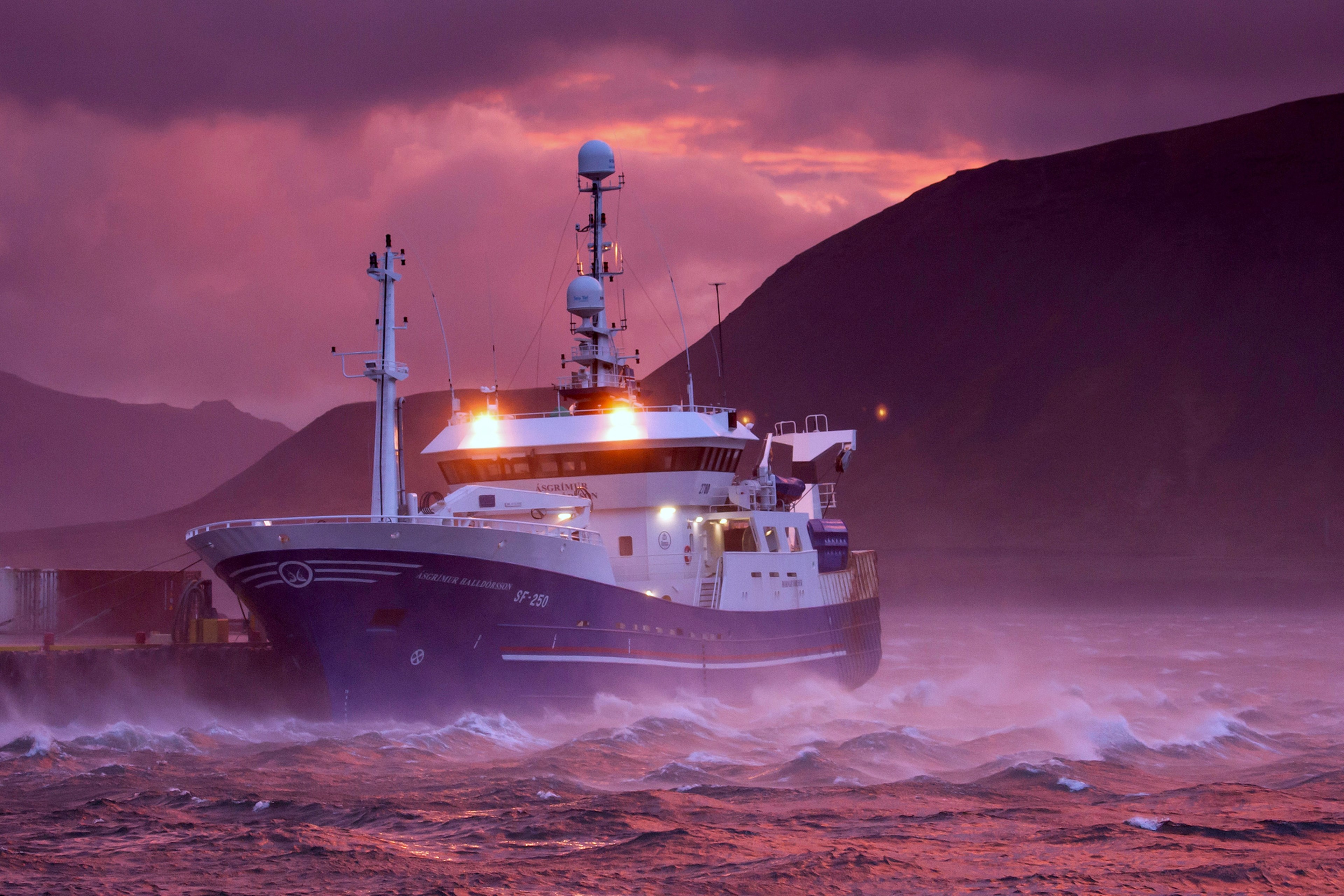Fishing boat in rough seas at sunset HD Wallpaper