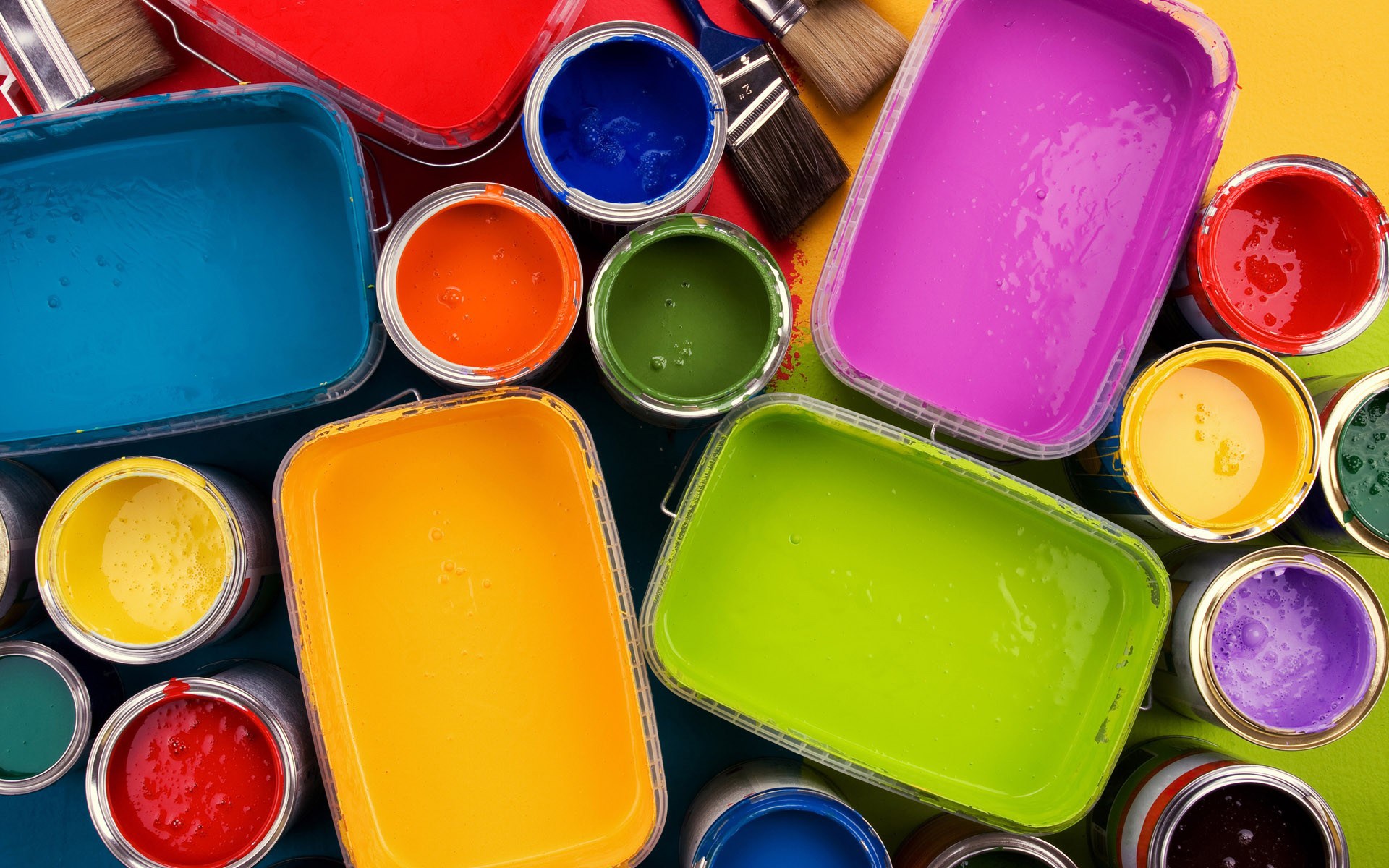 Assortment of colorful paint cans and brushes HD Wallpaper