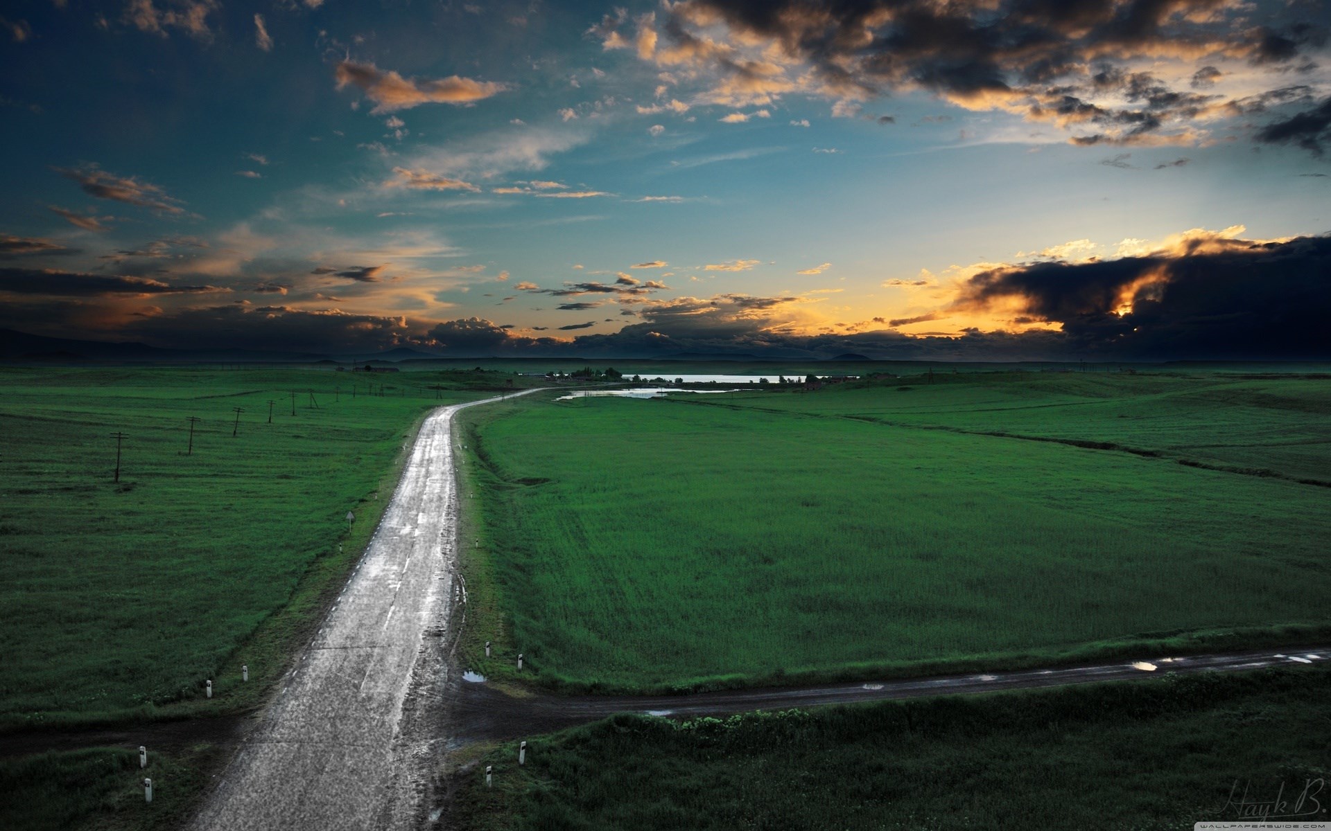 Road through green fields at sunset HD Wallpaper