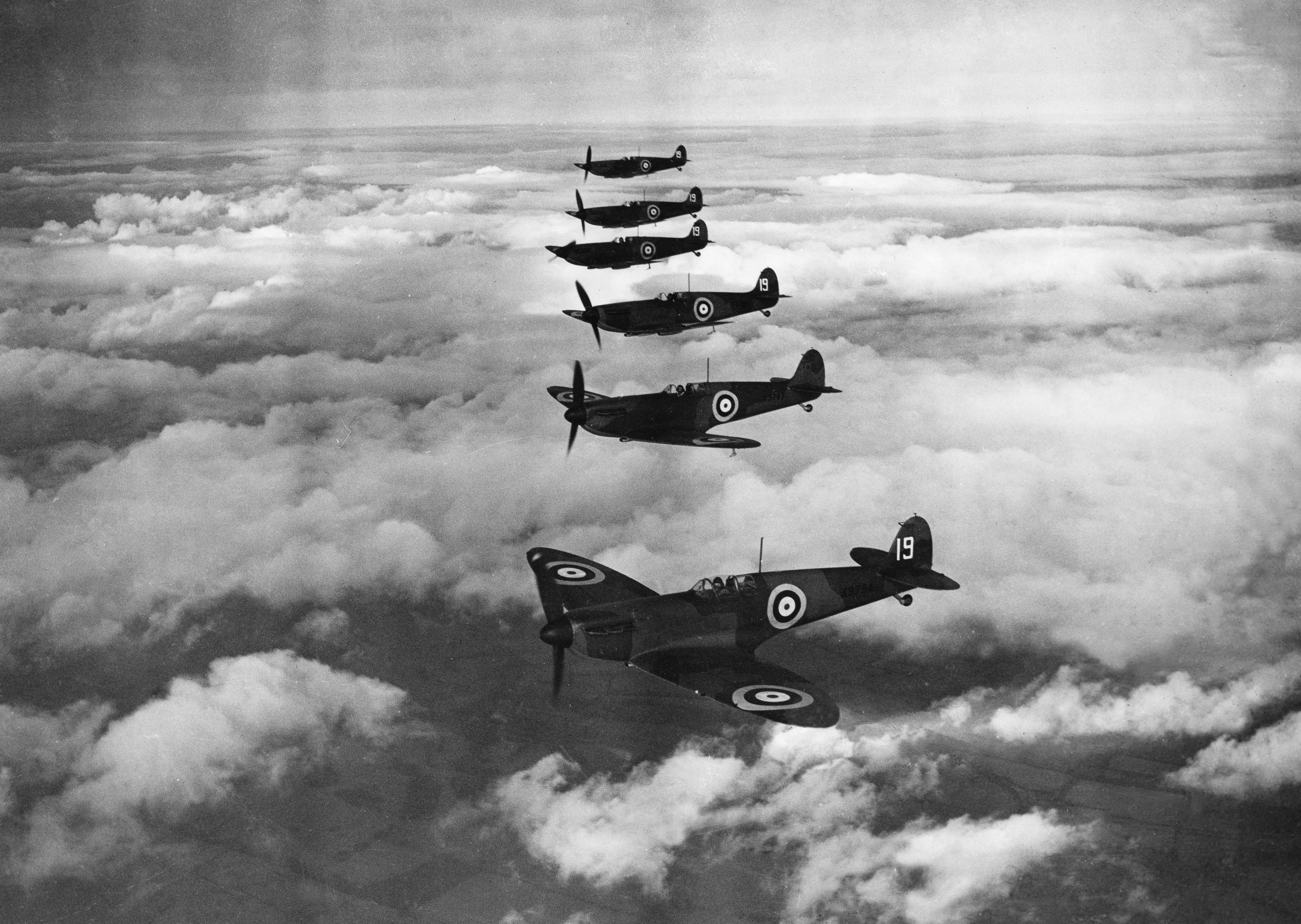 Supermarine Spitfires flying in formation over clouds HD Wallpaper