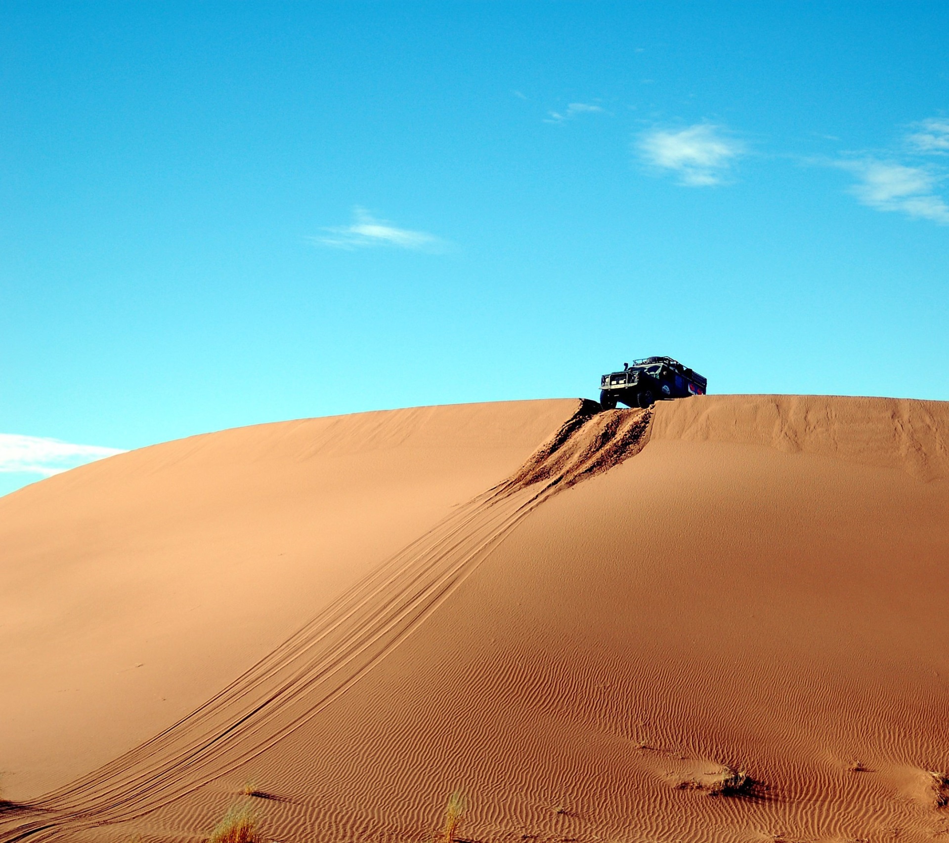 Offroad vehicle driving up a sand dune HD Wallpaper