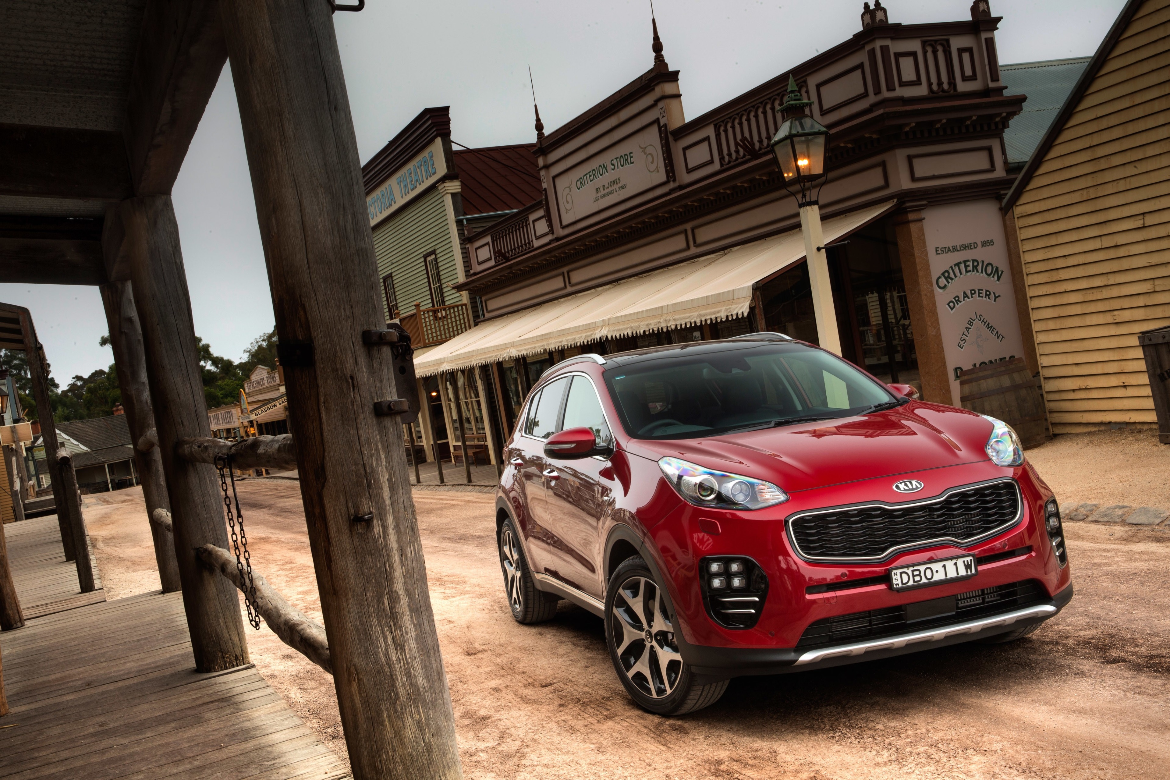 Red Kia Sportage in Old Western Town HD Wallpaper