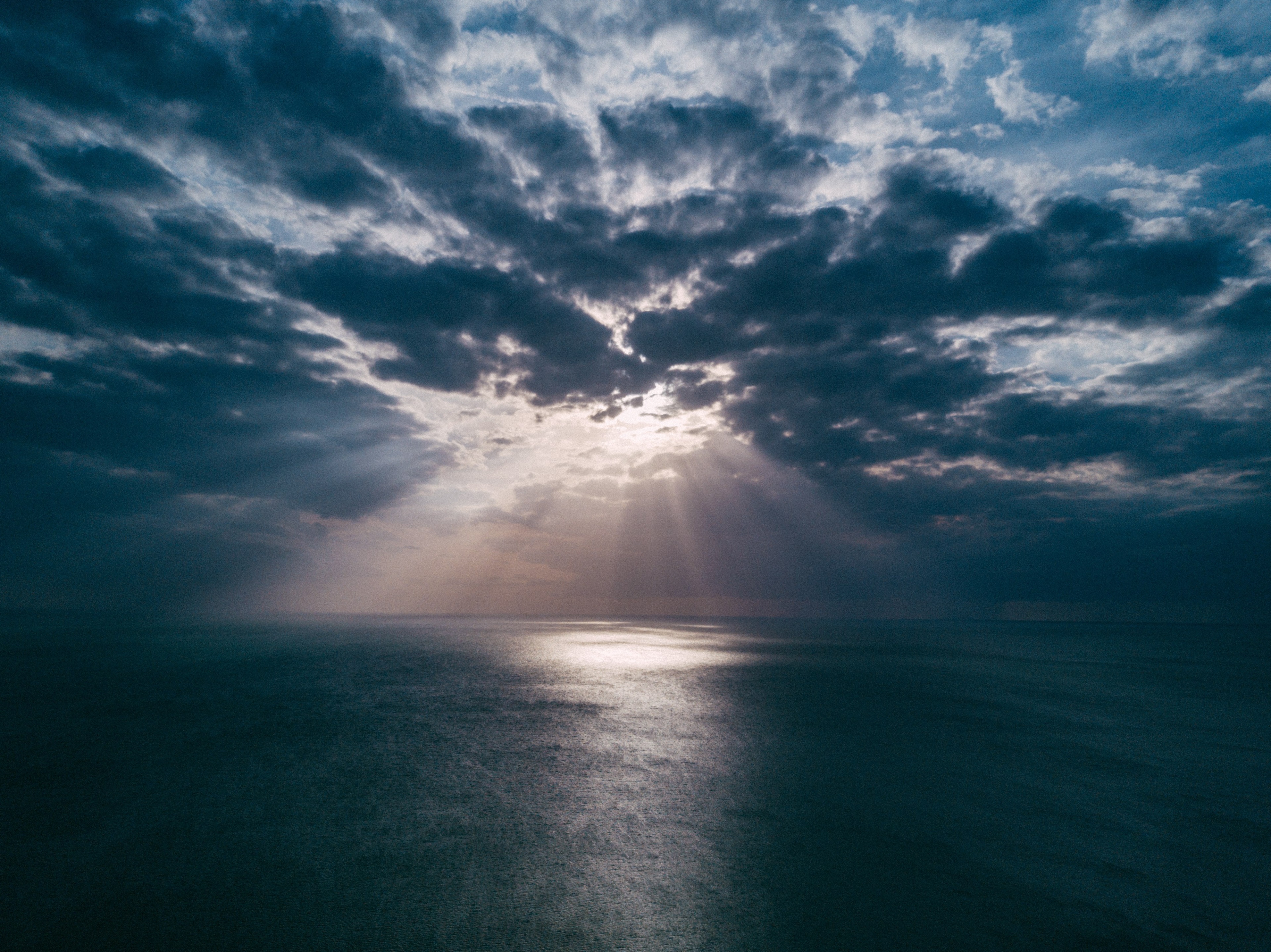 Sunbeams through clouds over the ocean HD Wallpaper