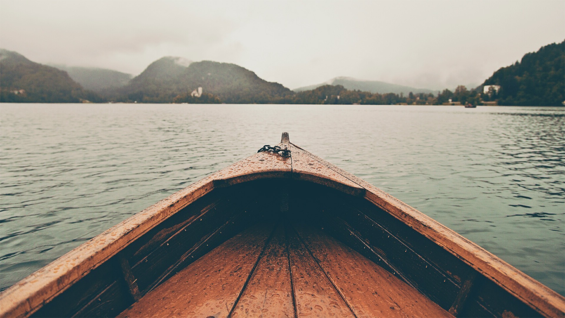 Boat on a lake with mountains in the background HD Wallpaper