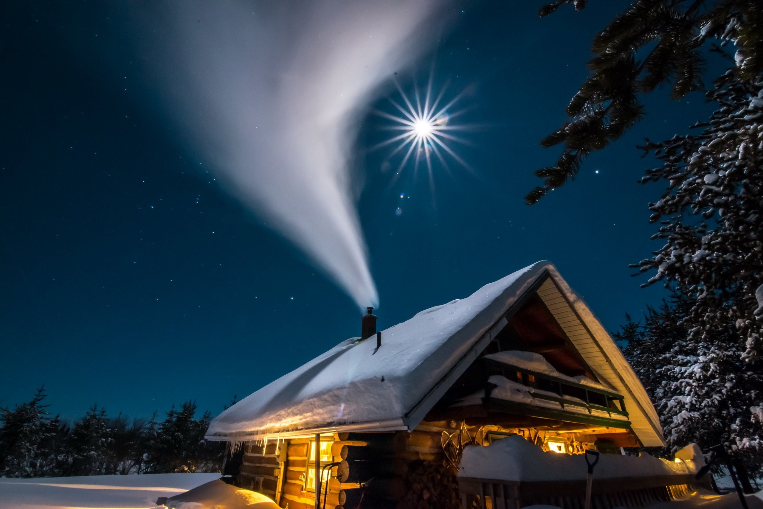Log cabin in winter at night with smoke from chimney under moonlight HD Wallpaper