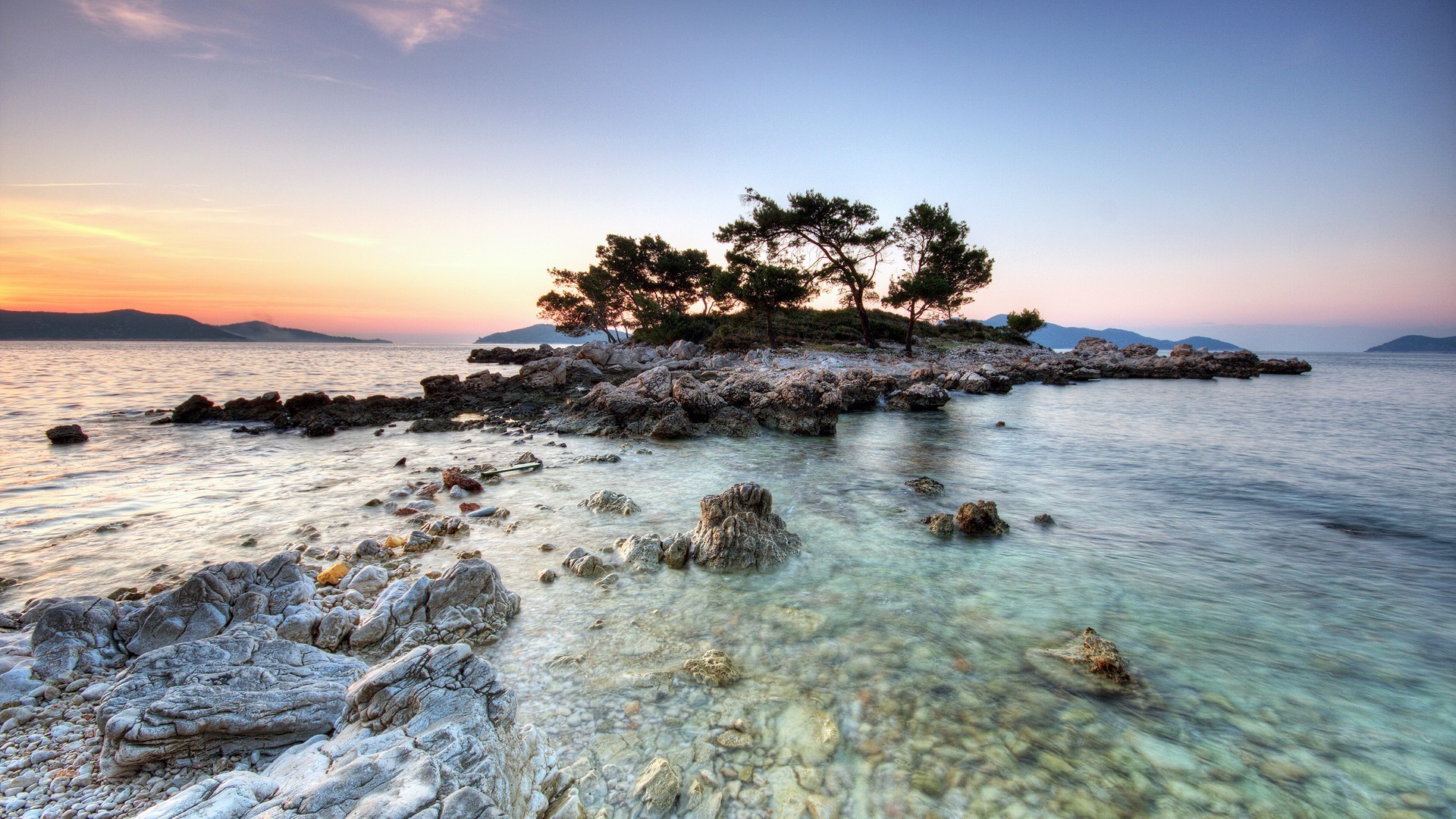 Island with trees and rocks in the sea at sunset HD Wallpaper