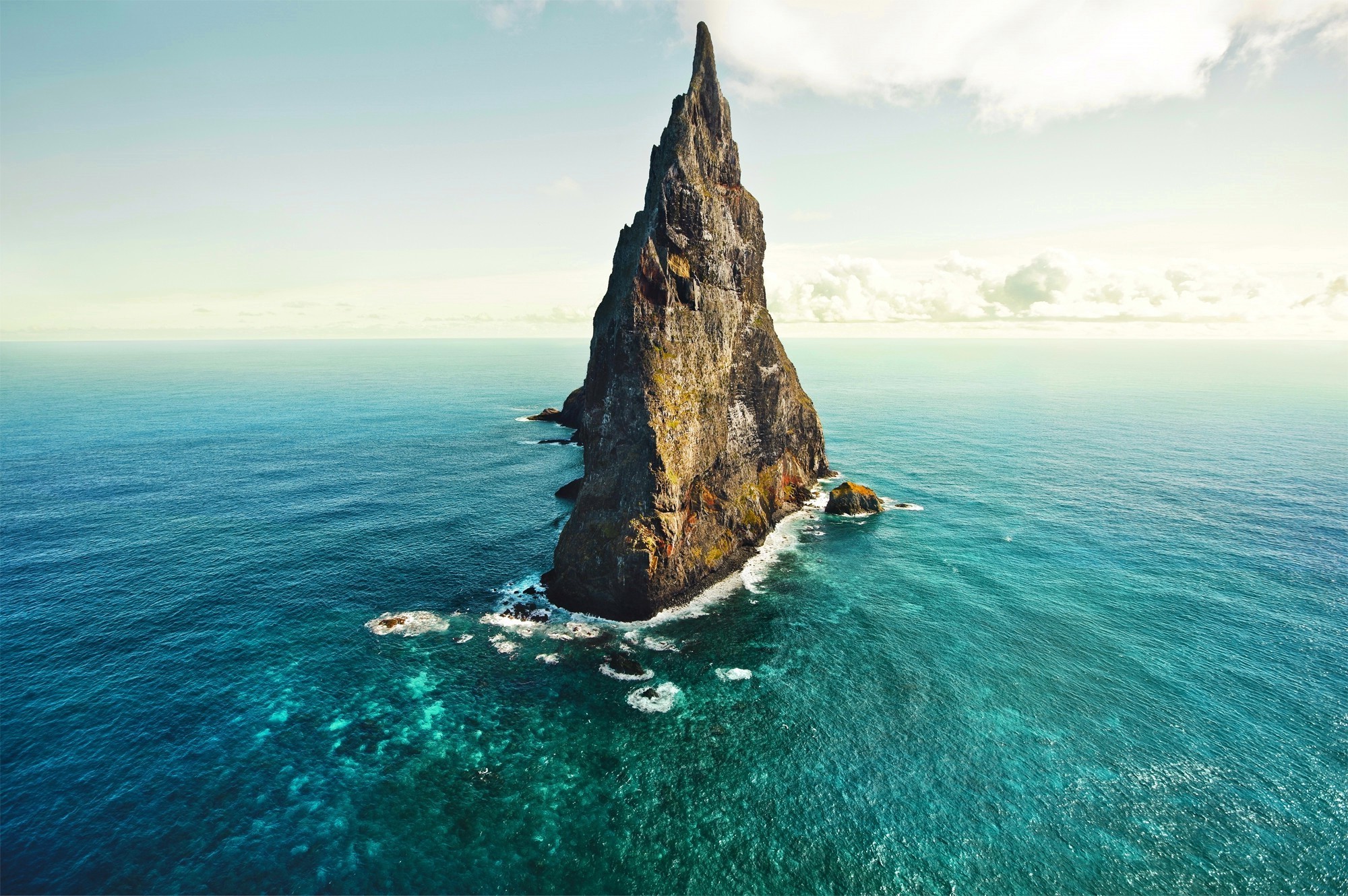 Tall rock formation in the ocean HD Wallpaper