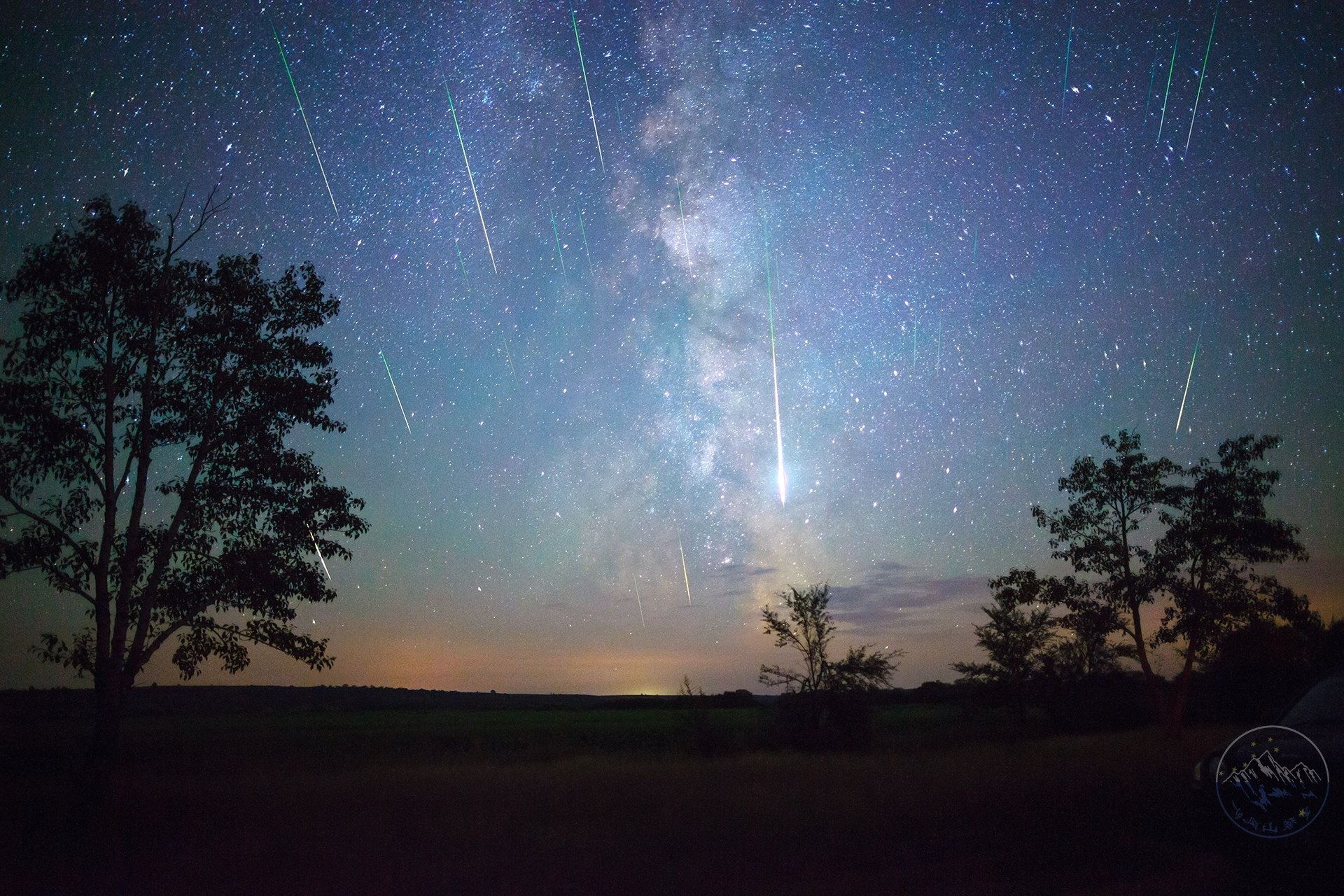 Milky Way and meteor shower over landscape HD Wallpaper