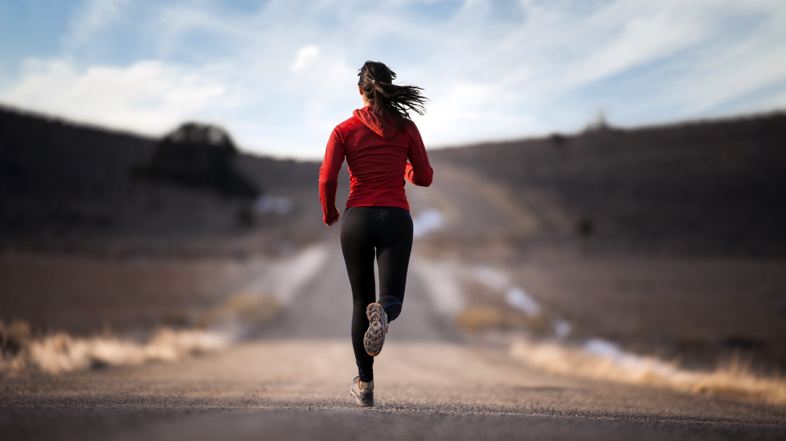 Woman running on a dirt road in the countryside HD Wallpaper
