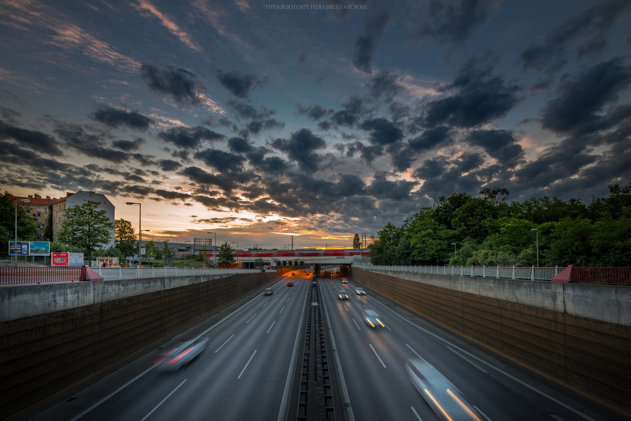 Highway at sunset with motion blur and dramatic clouds HD Wallpaper