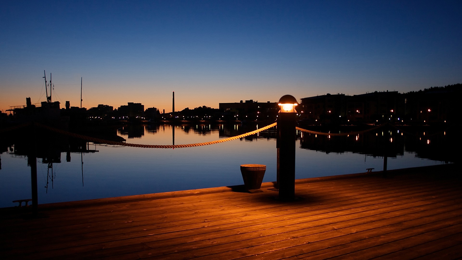 Dock at night with city skyline reflection HD Wallpaper