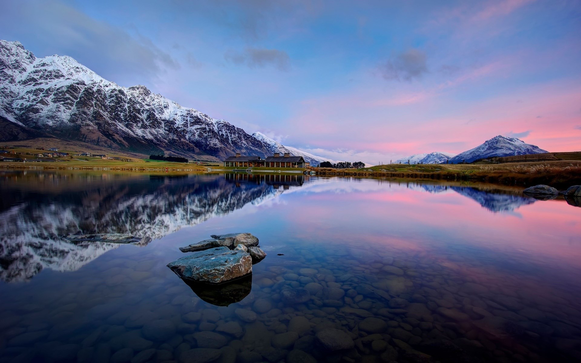 Snow-capped mountains reflected in a calm lake at sunset HD Wallpaper