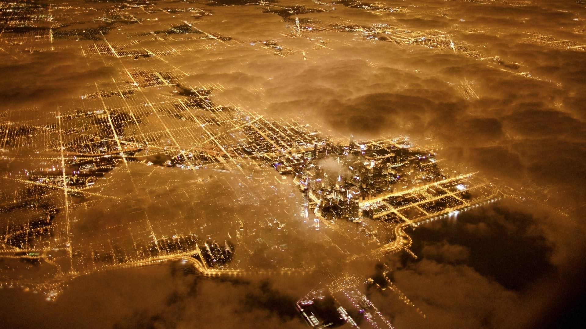 Aerial view of Chicago cityscape at night through clouds HD Wallpaper