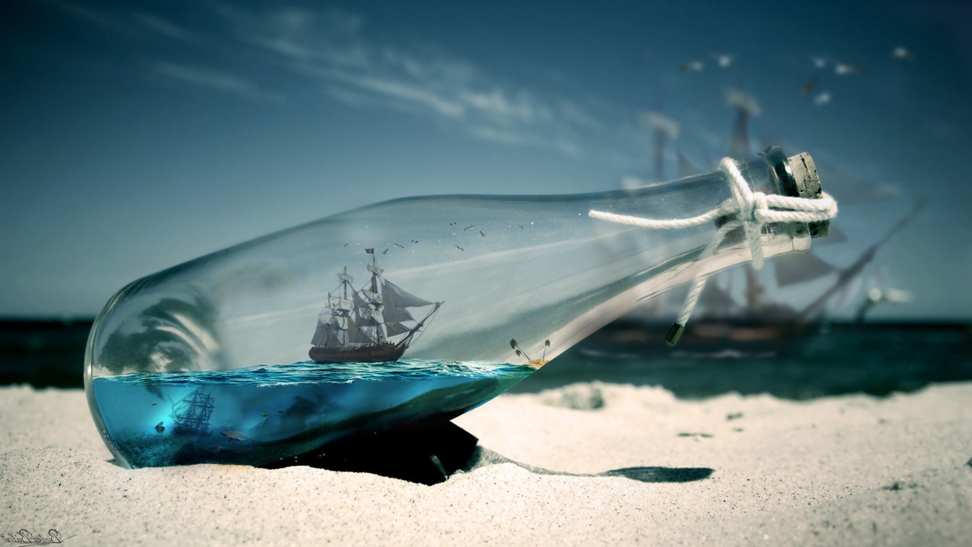 Ship in a bottle on a sandy beach HD Wallpaper