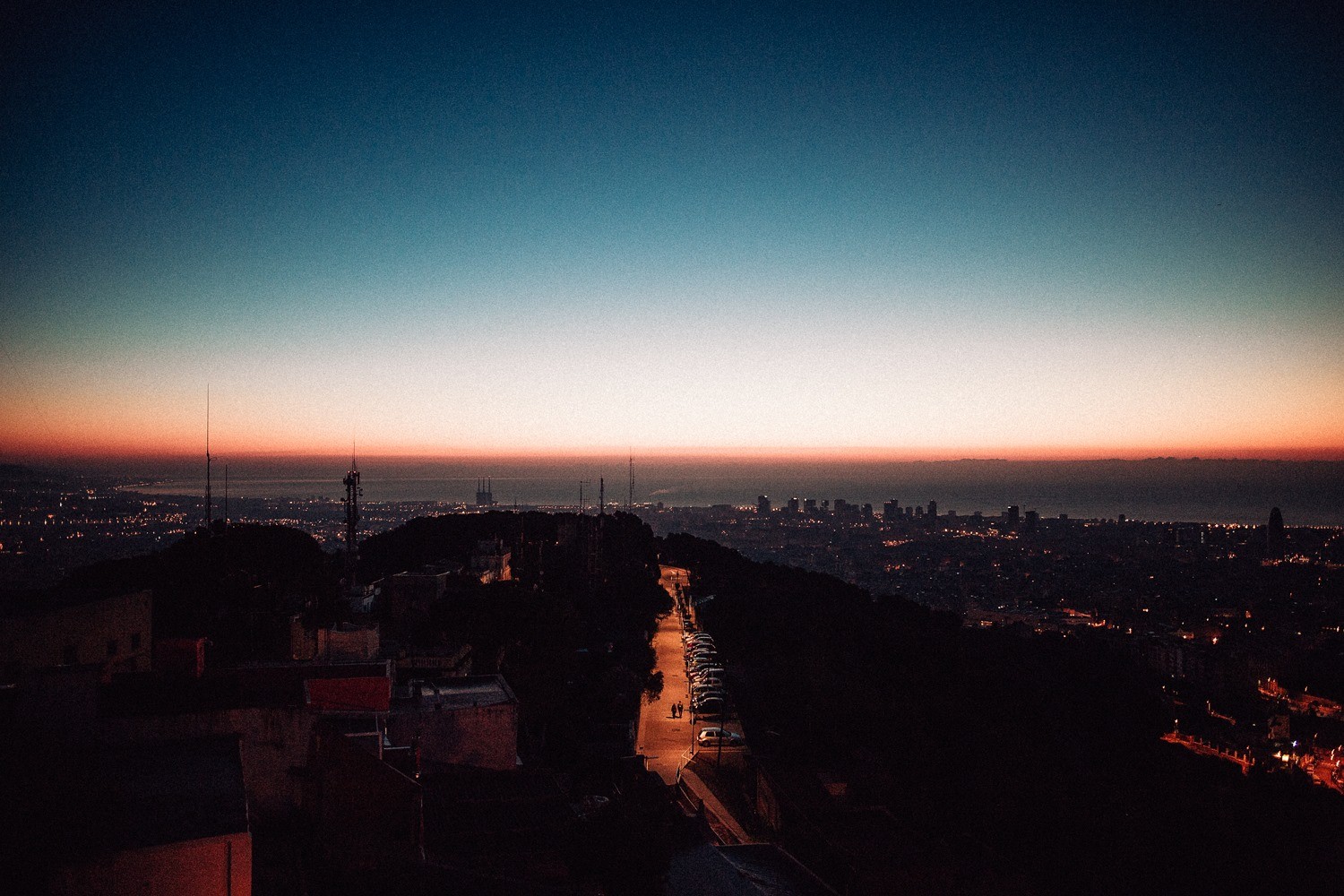 Cityscape at dusk with a road and lights HD Wallpaper