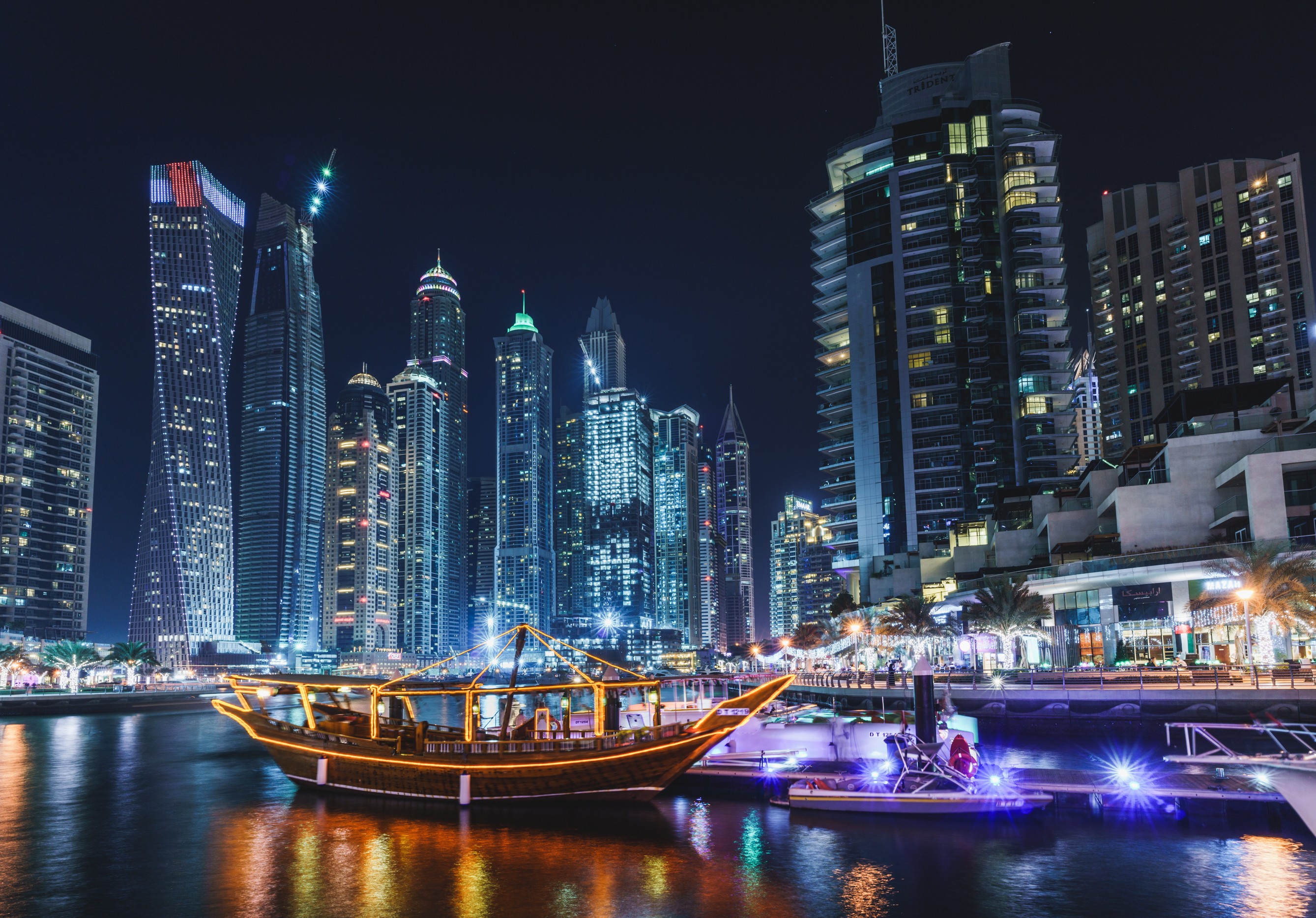 Dubai cityscape at night with a traditional boat HD Wallpaper