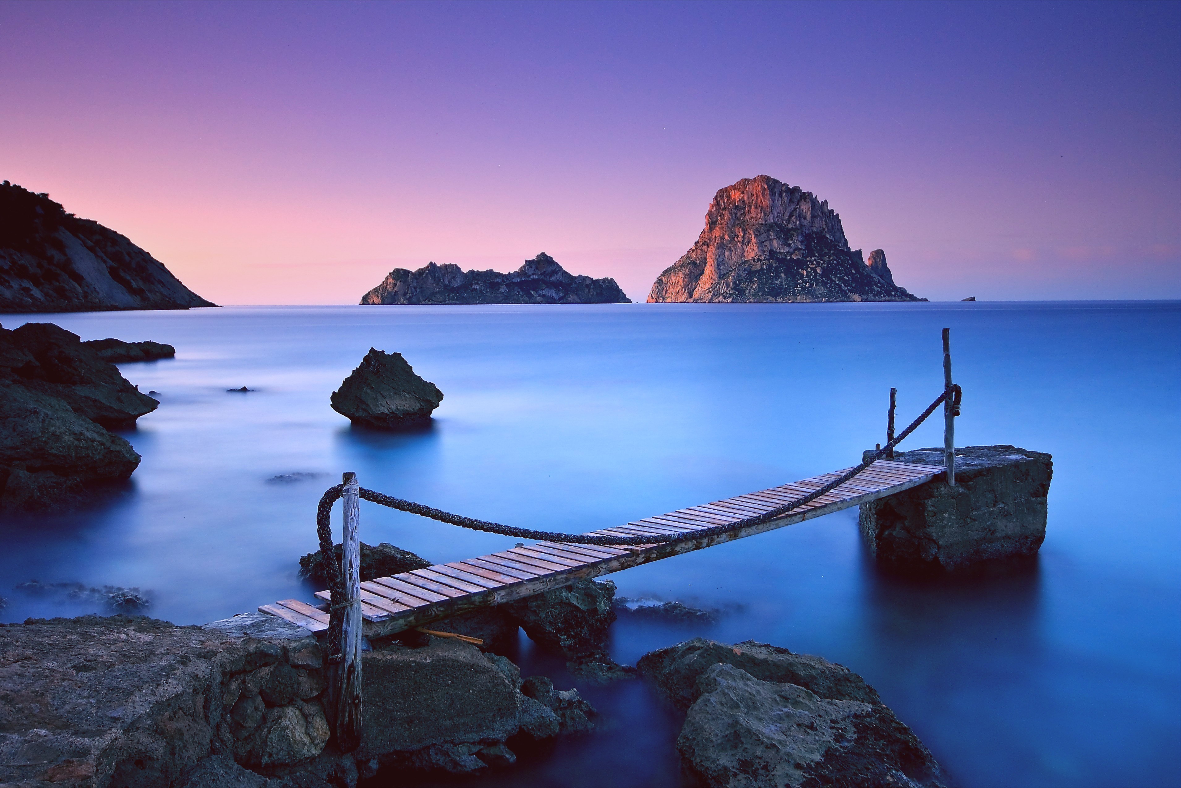 Wooden pier and rocky islands in the sea at sunset HD Wallpaper