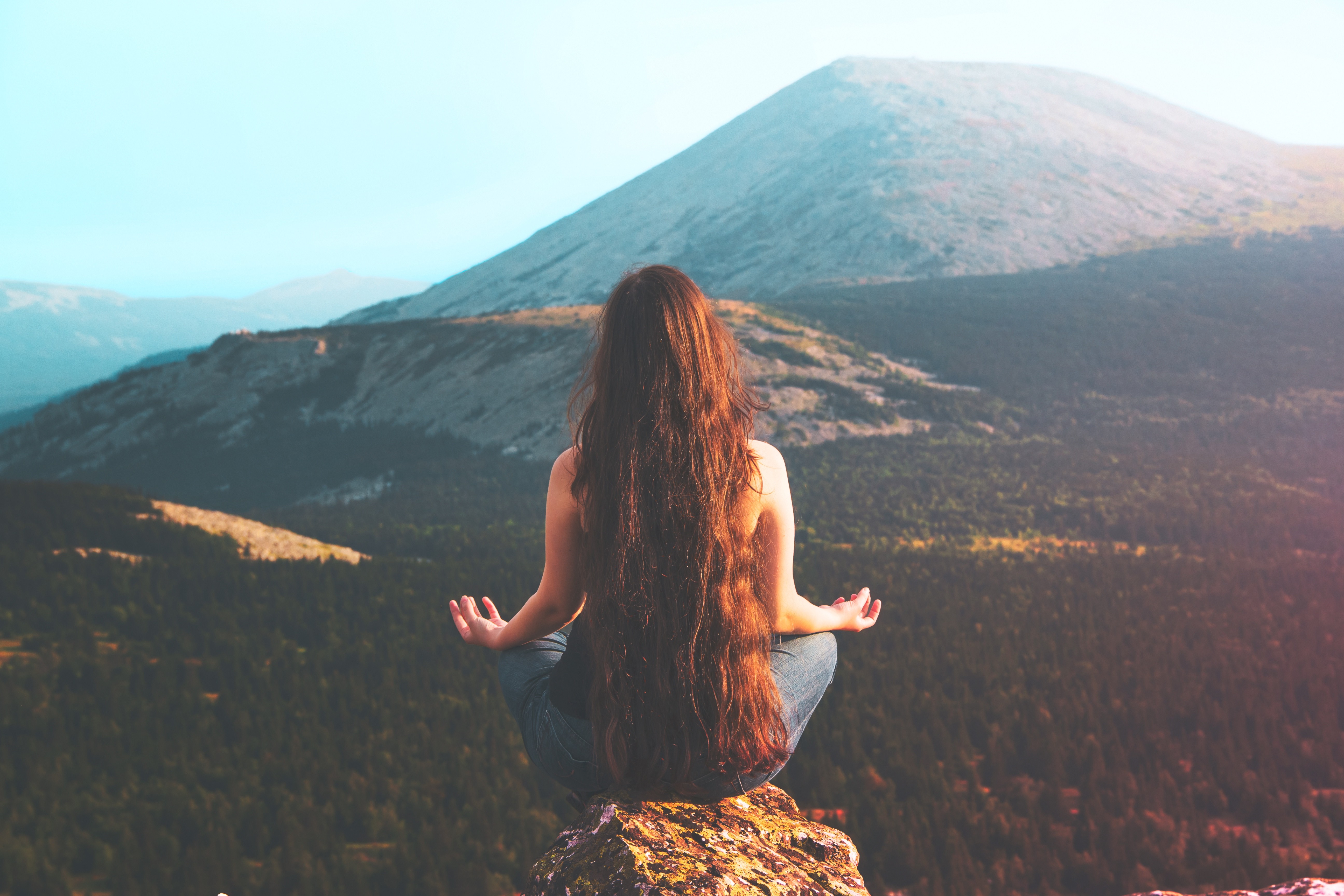Woman meditating on a mountain top HD Wallpaper
