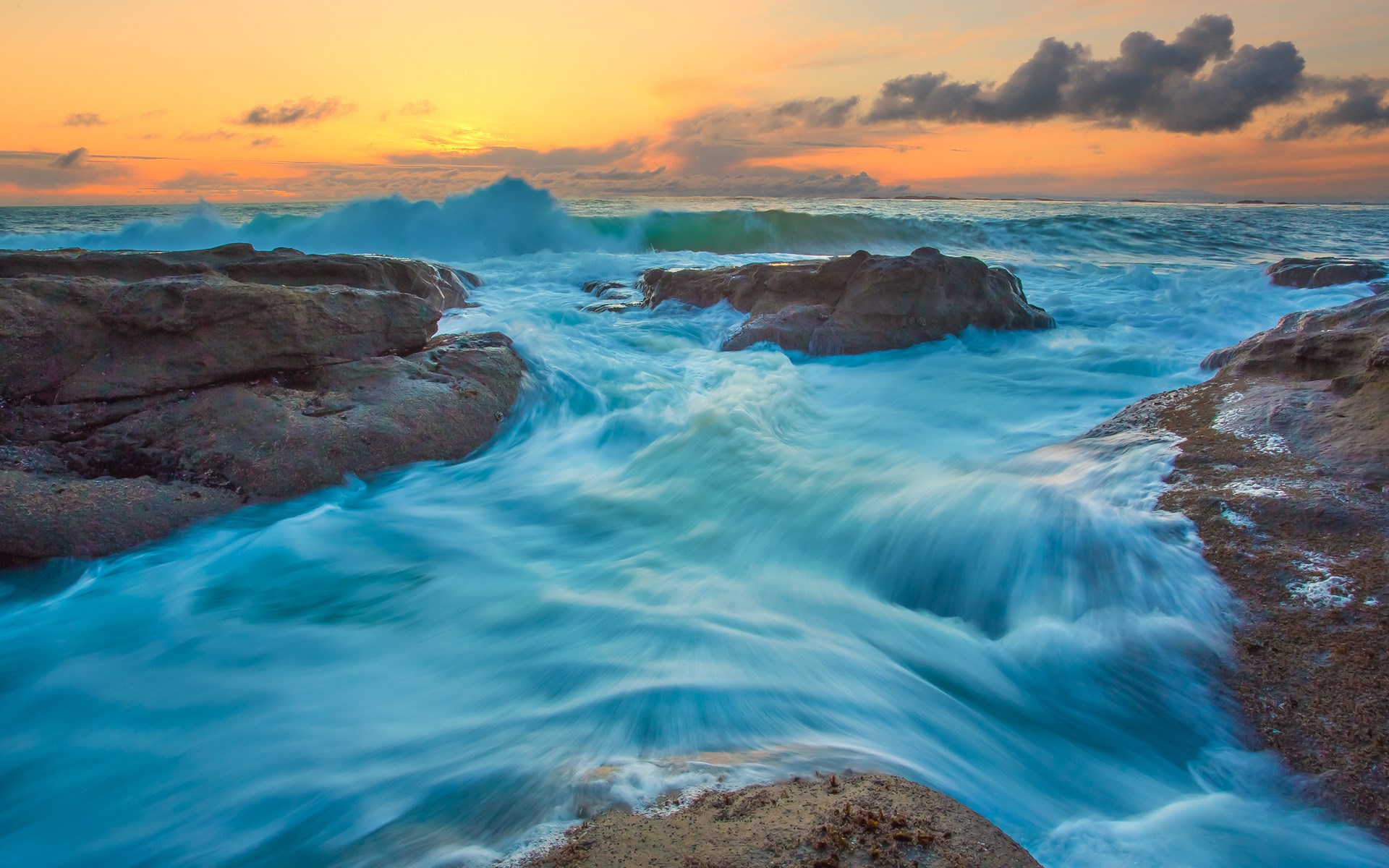 Ocean waves crashing on rocks at sunset HD Wallpaper