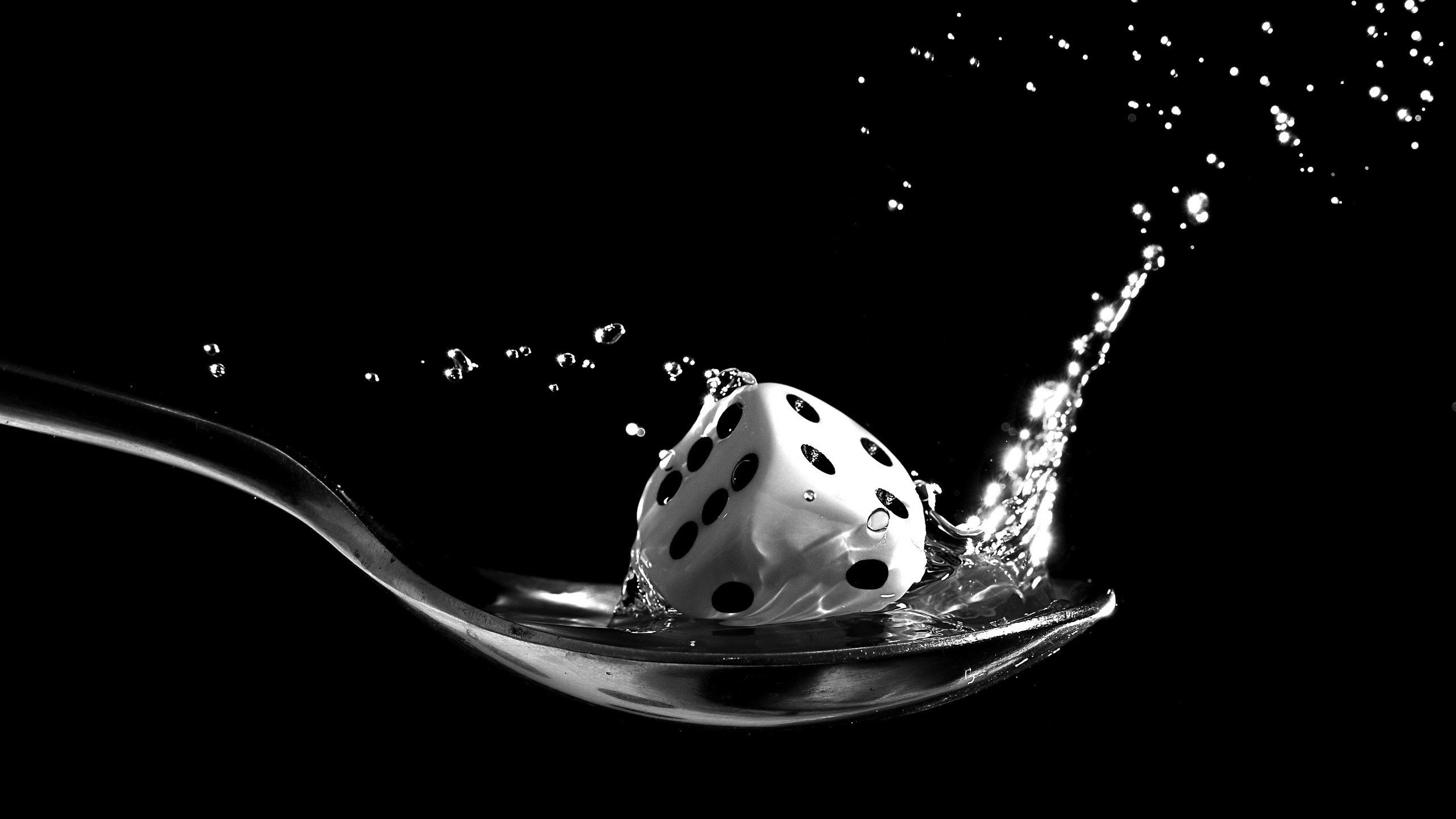 Dice splashing into water on a spoon HD Wallpaper