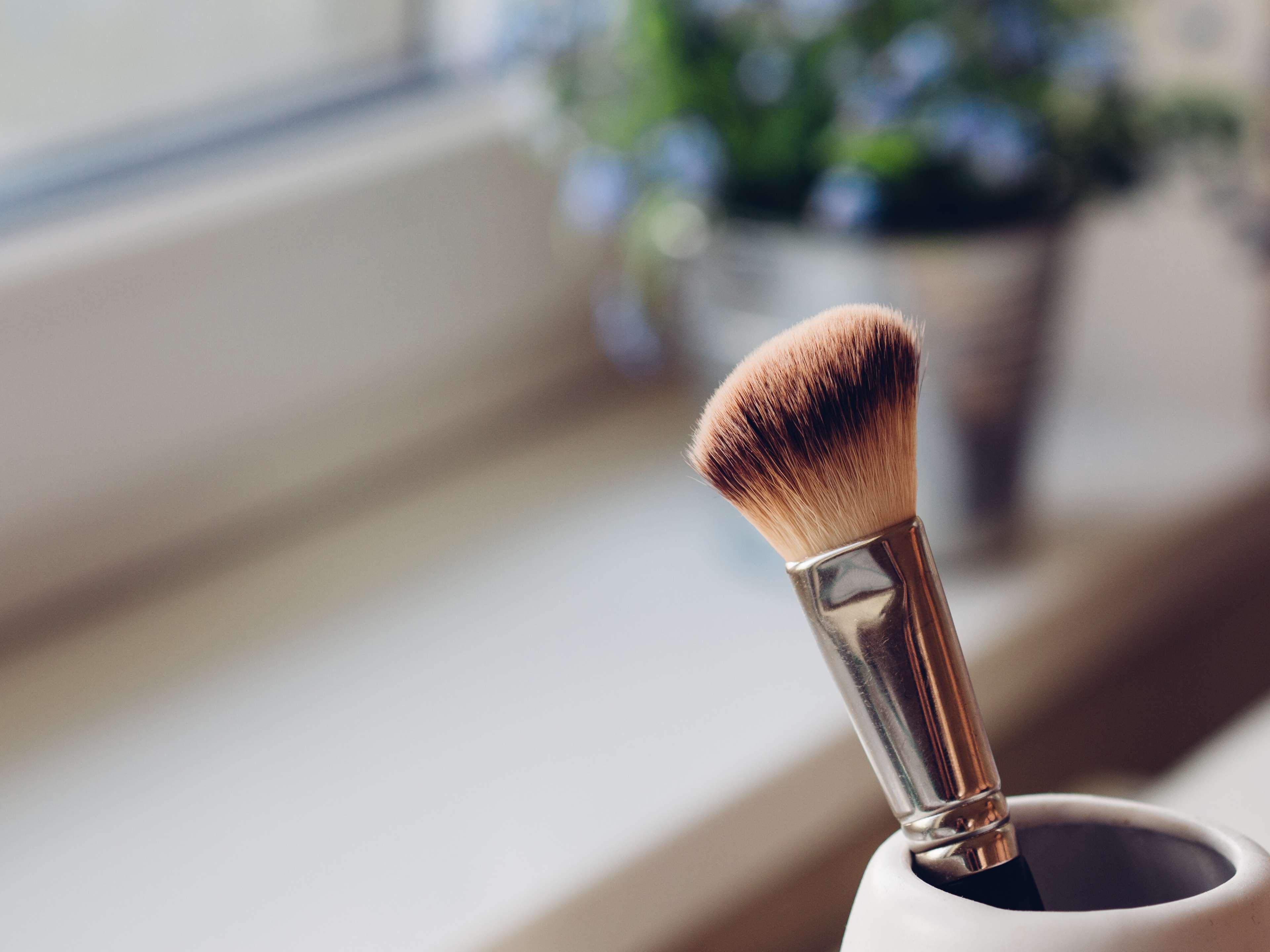 Makeup brush in a cup by the window HD Wallpaper