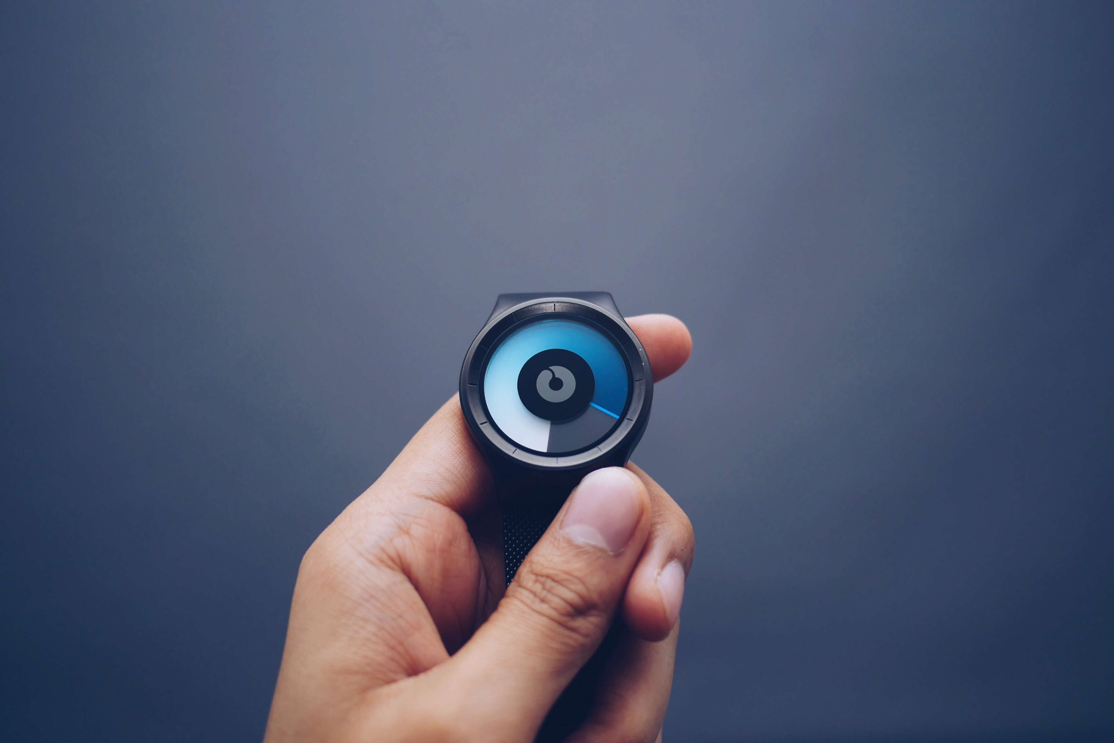 Hand holding a futuristic smartwatch with a unique display HD Wallpaper