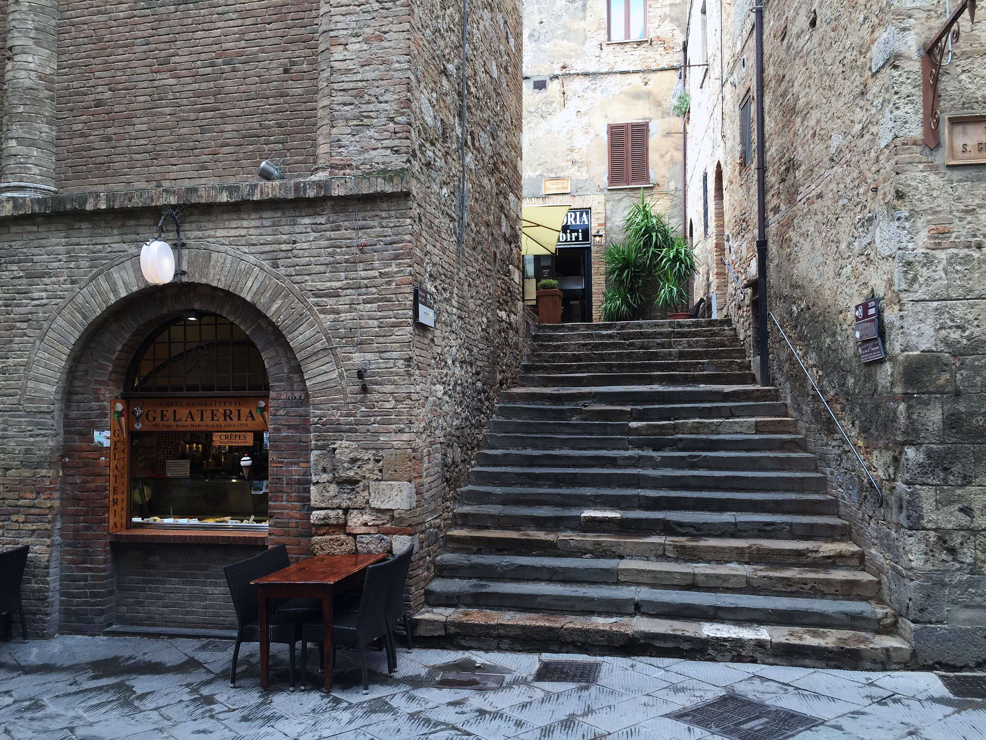 Gelateria with outdoor seating and stone stairs in Italy HD Wallpaper