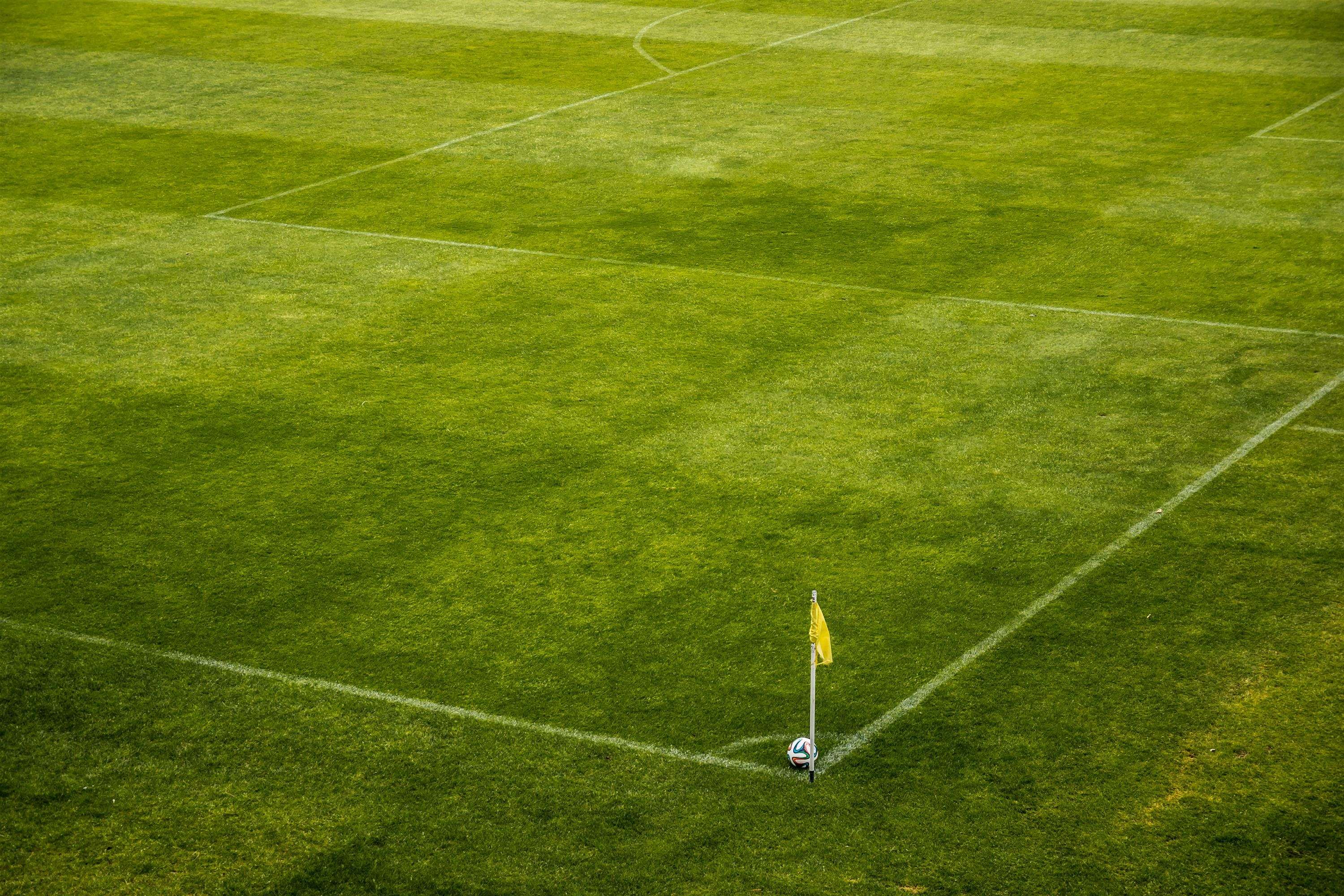 Soccer ball and flag on a grassy field HD Wallpaper