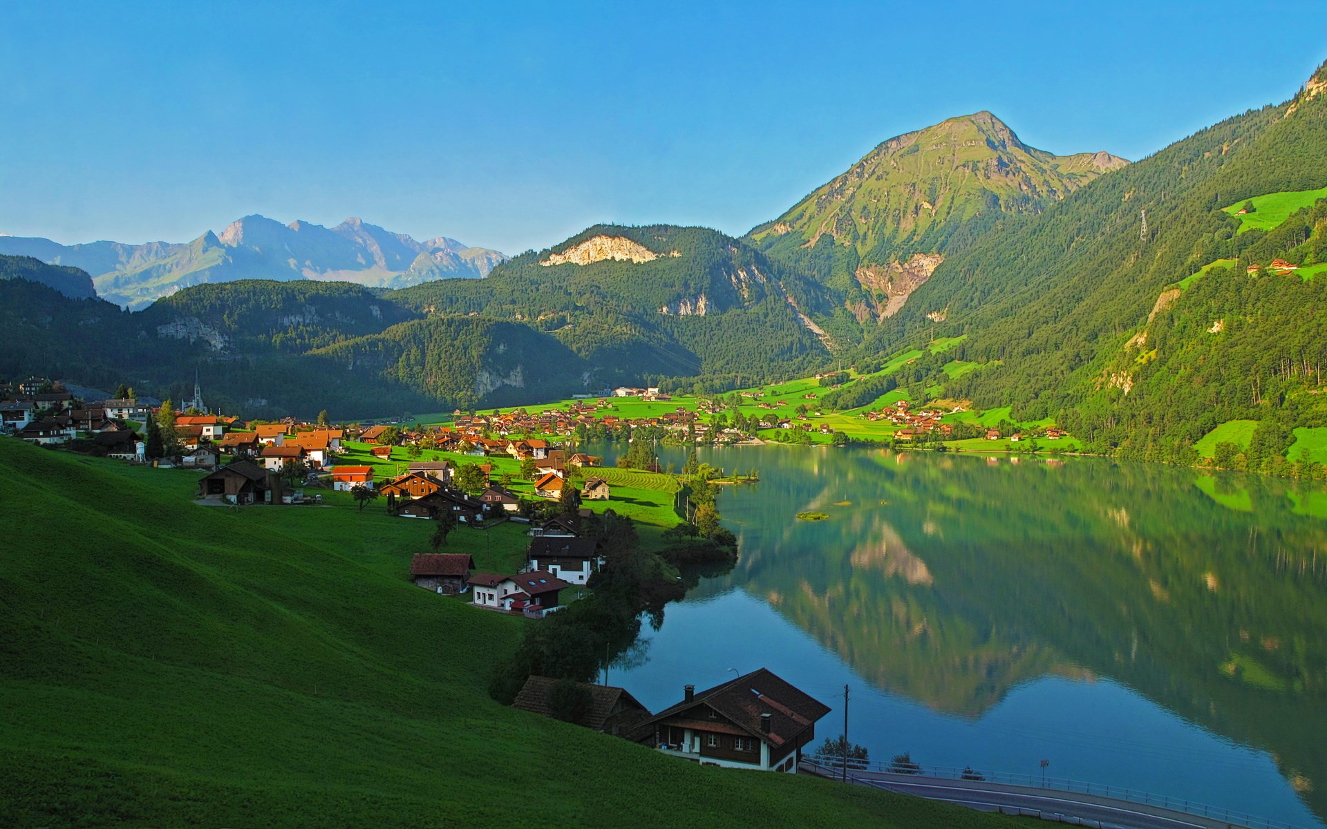 Village on a lake with mountains HD Wallpaper