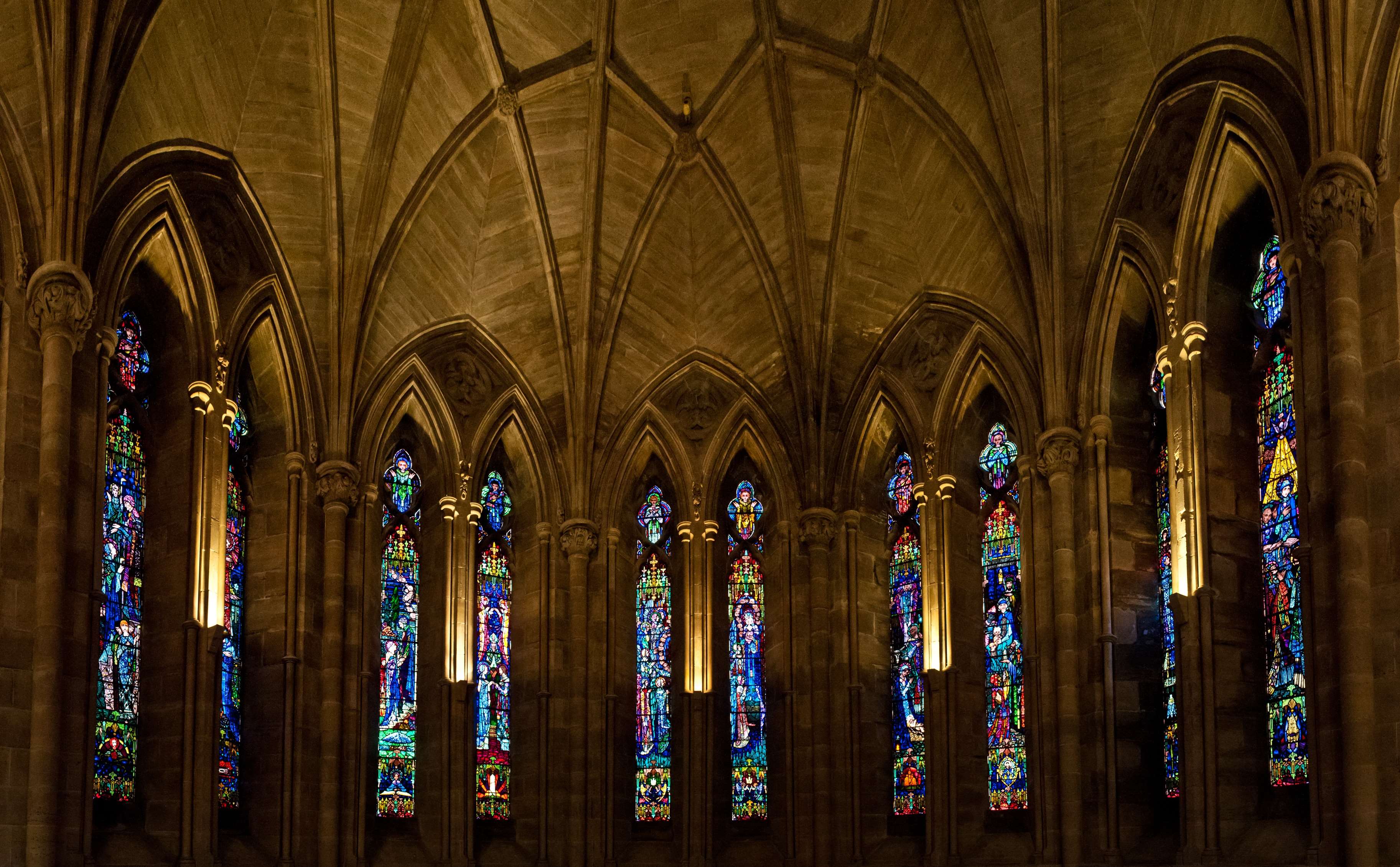 Interior of a Gothic cathedral with stained glass windows HD Wallpaper