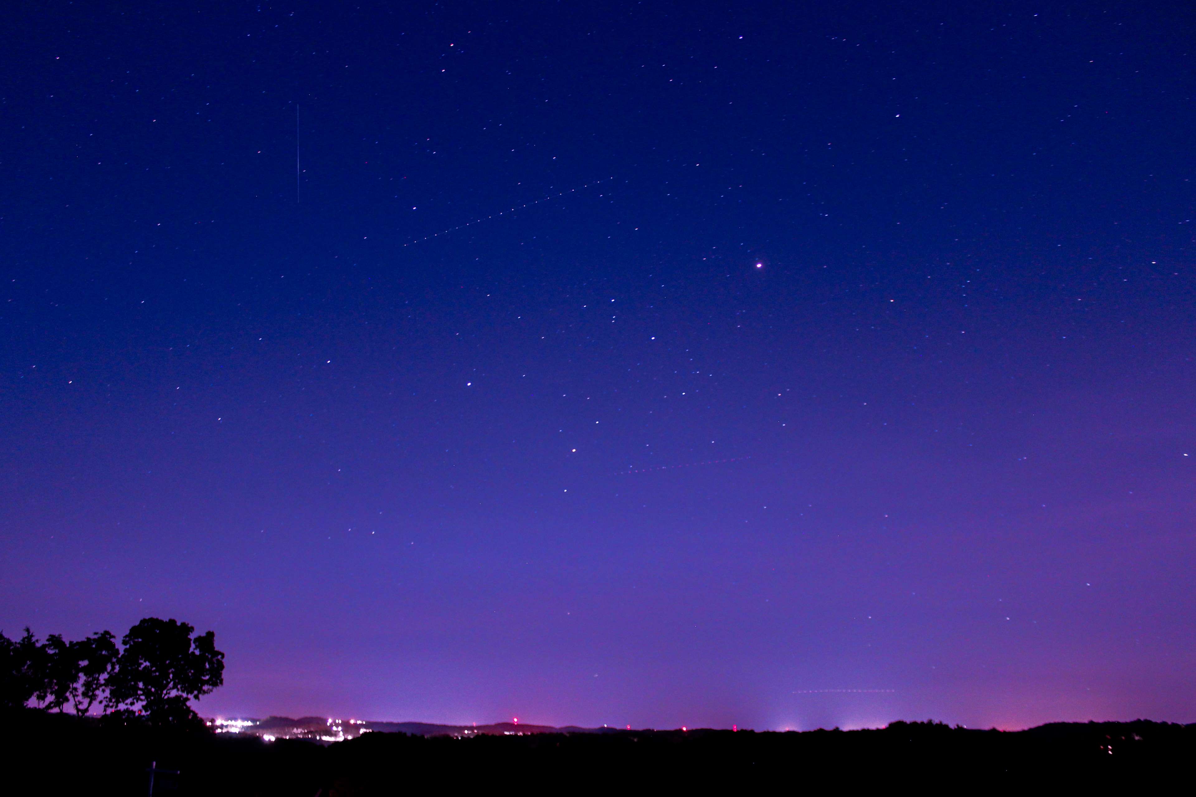 Night sky with stars and distant city lights HD Wallpaper
