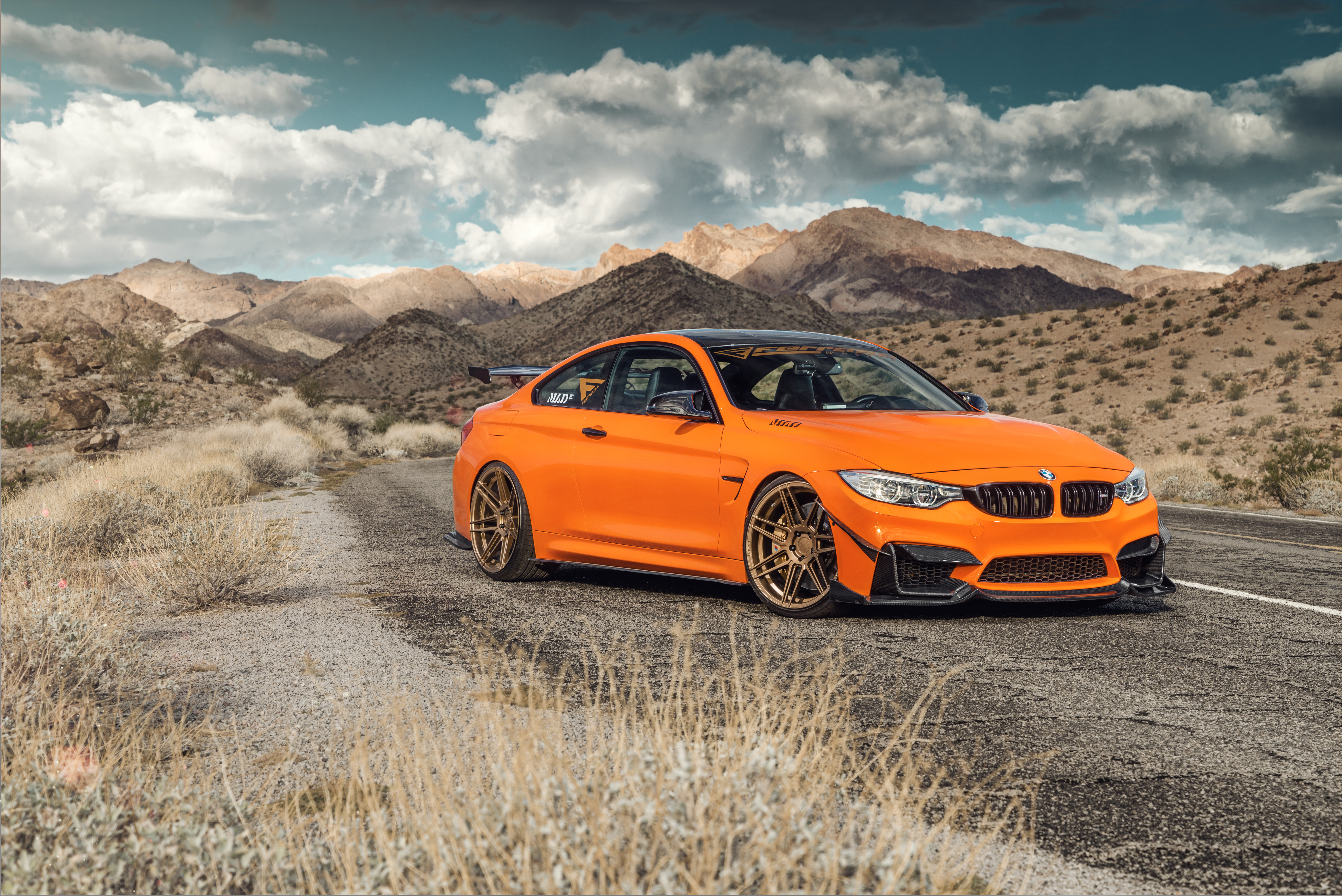 Orange BMW M4 coupe with spoiler in desert landscape HD Wallpaper
