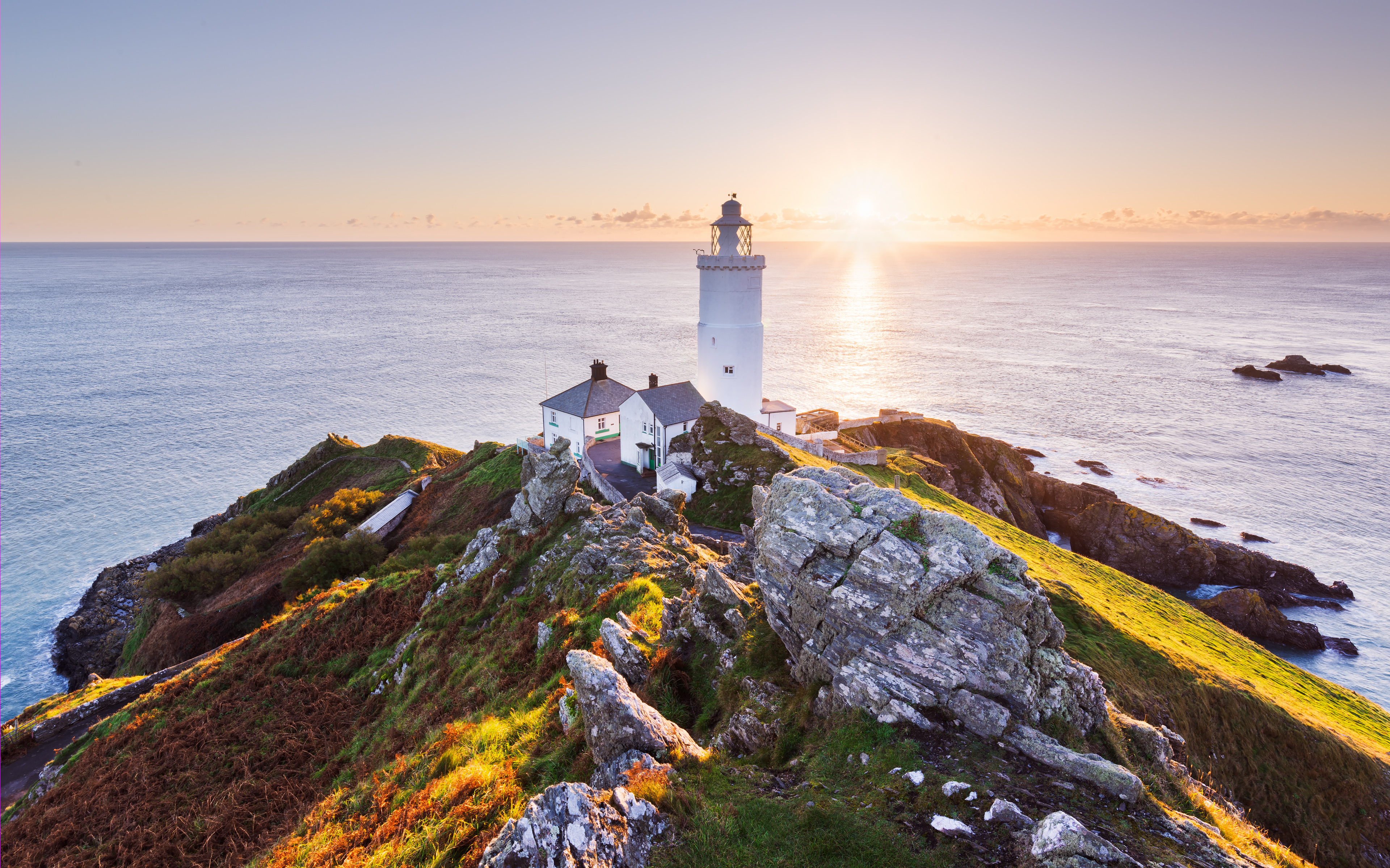 Lighthouse on a rocky coast at sunrise over the Atlantic Ocean HD Wallpaper