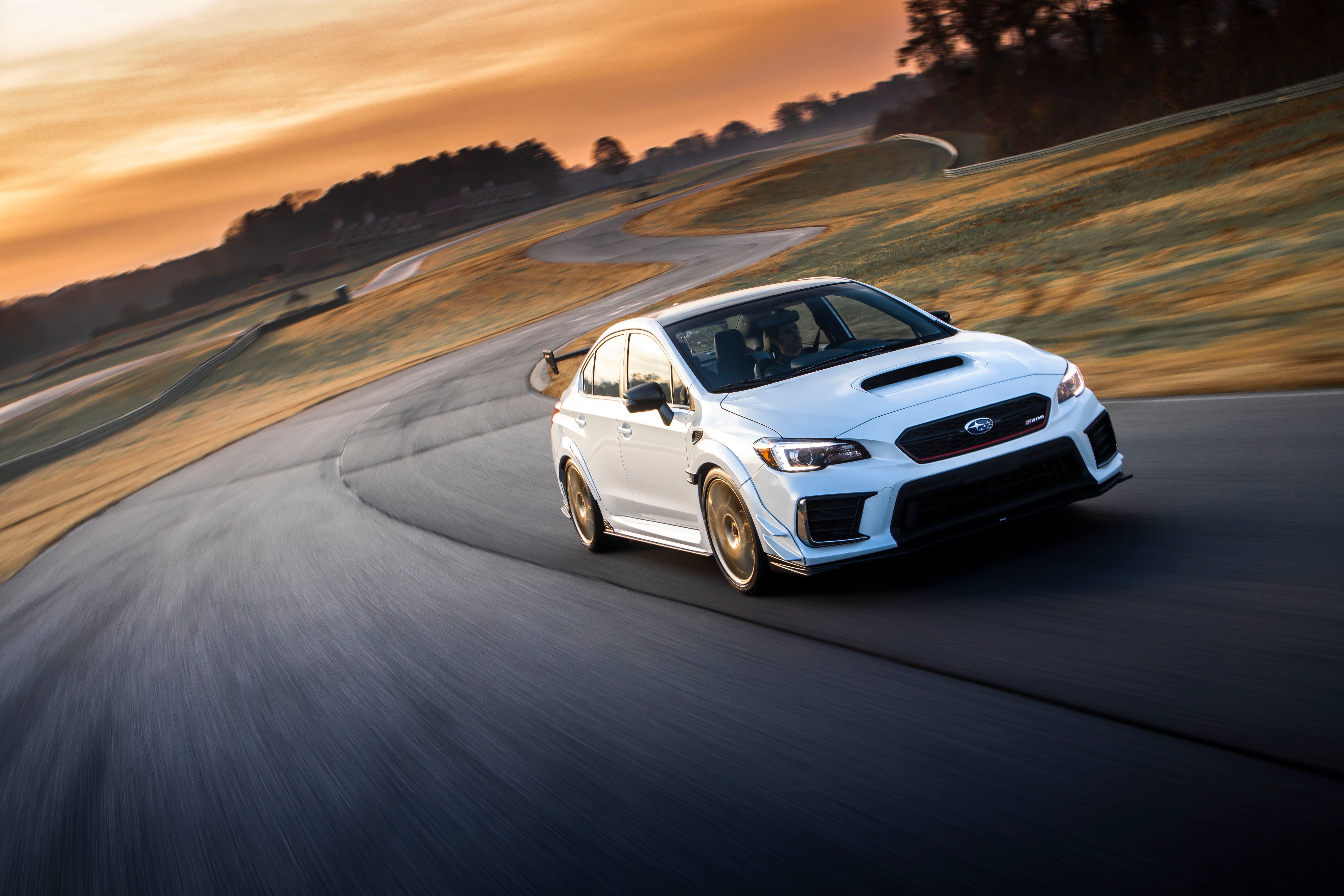 White Subaru WRX STI on a race track at sunset HD Wallpaper
