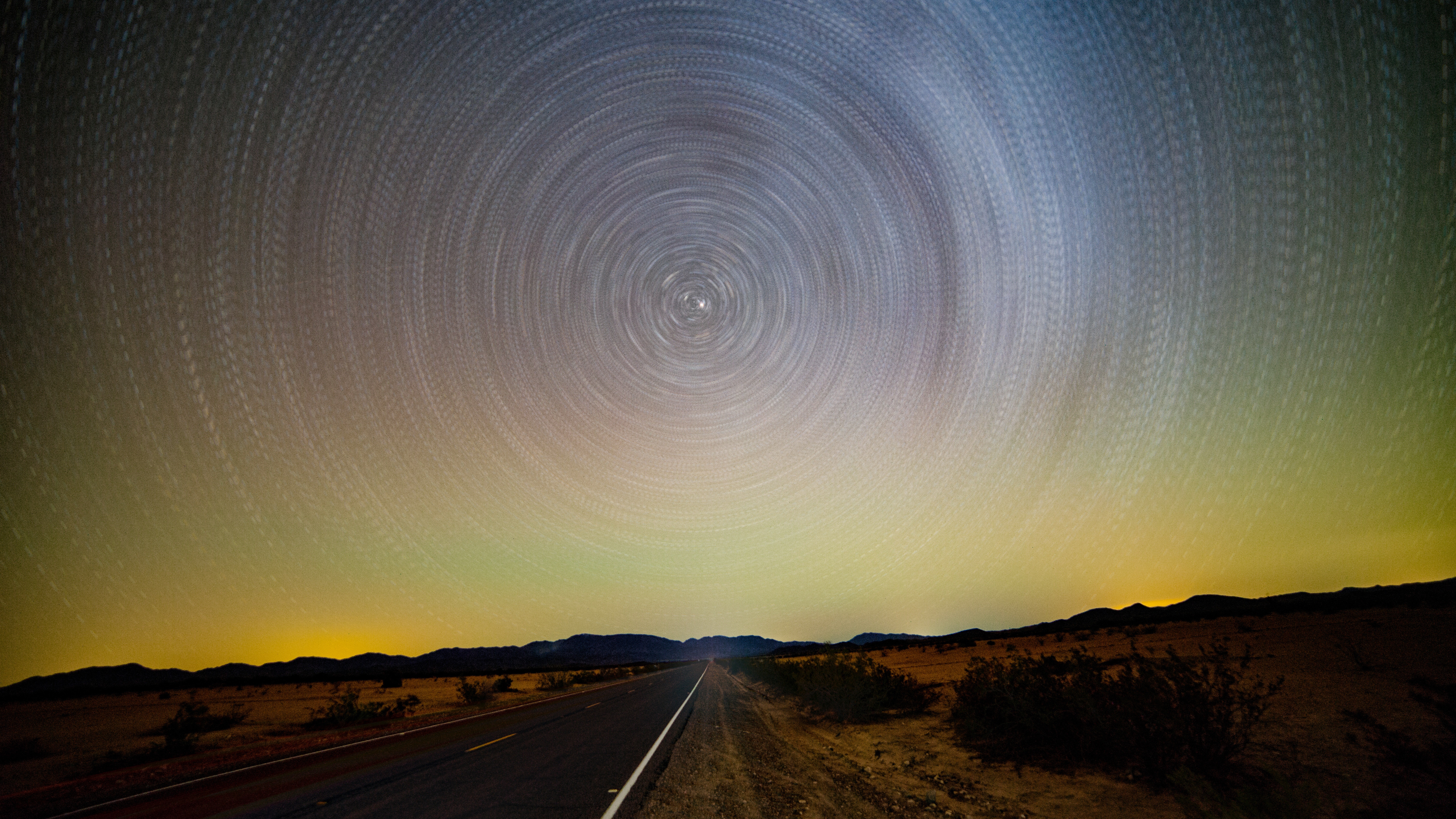 Star trails over a desert road at night HD Wallpaper