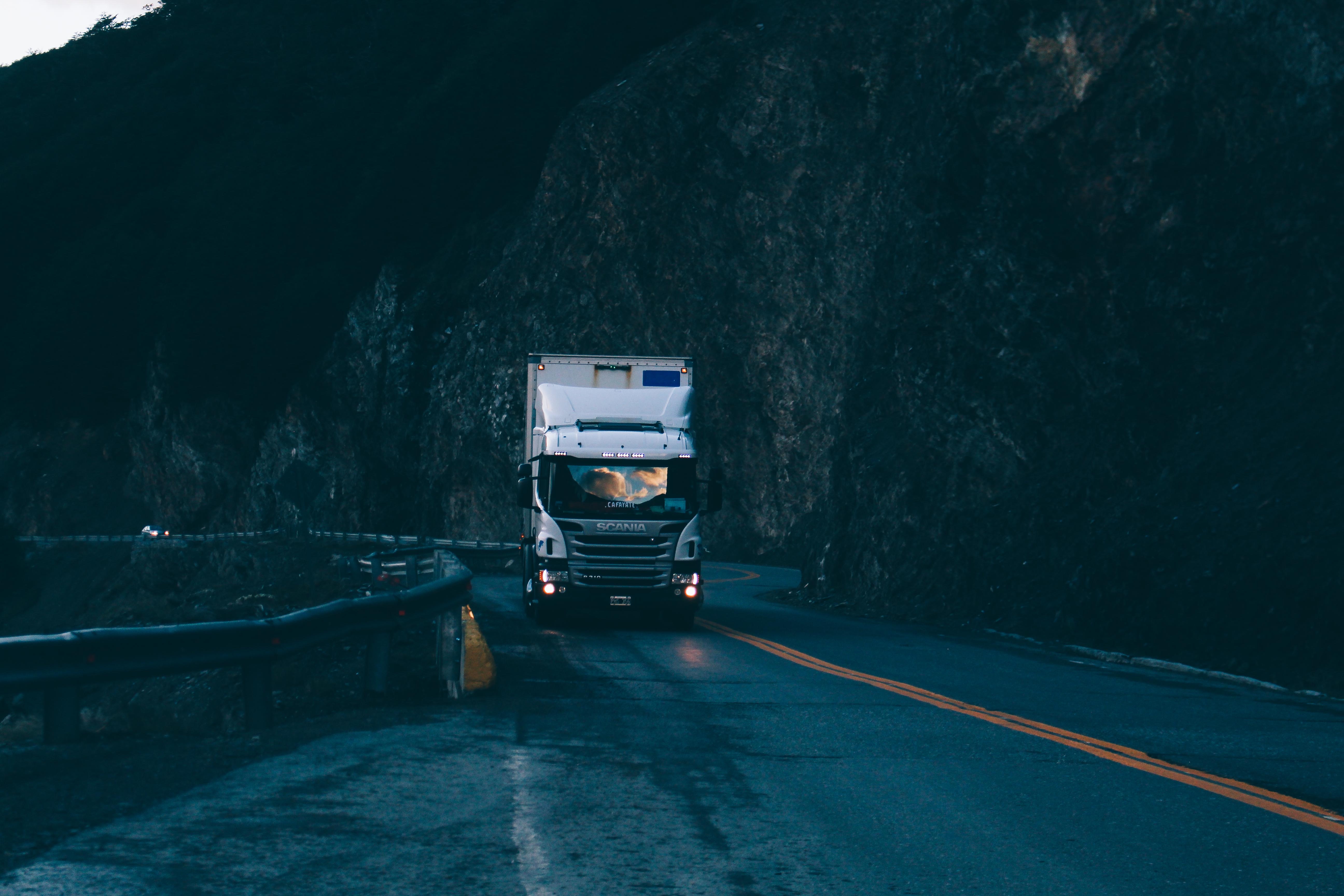 Truck driving on a mountain road at dusk HD Wallpaper