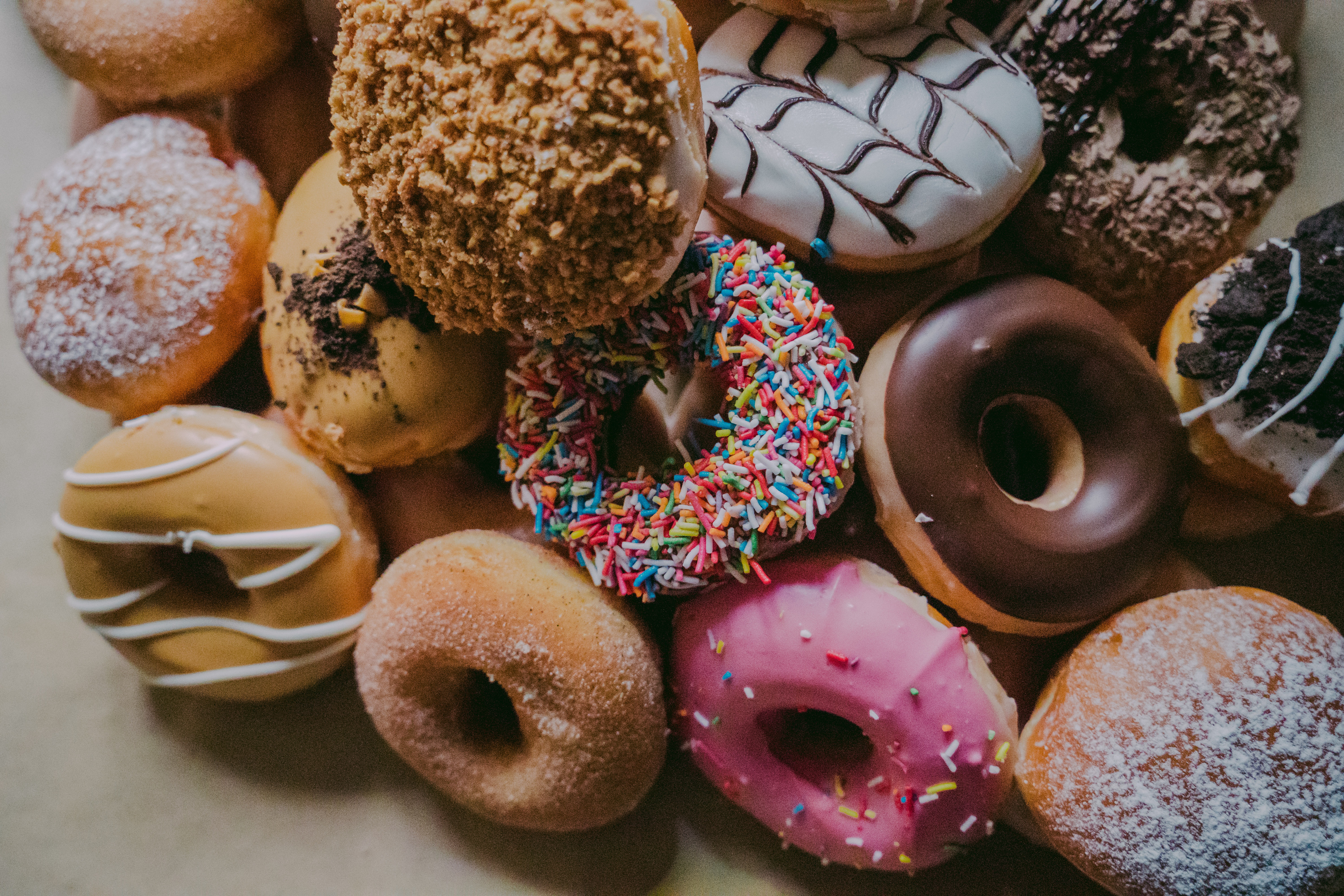 Assortment of Delicious Donuts with Various Toppings HD Wallpaper